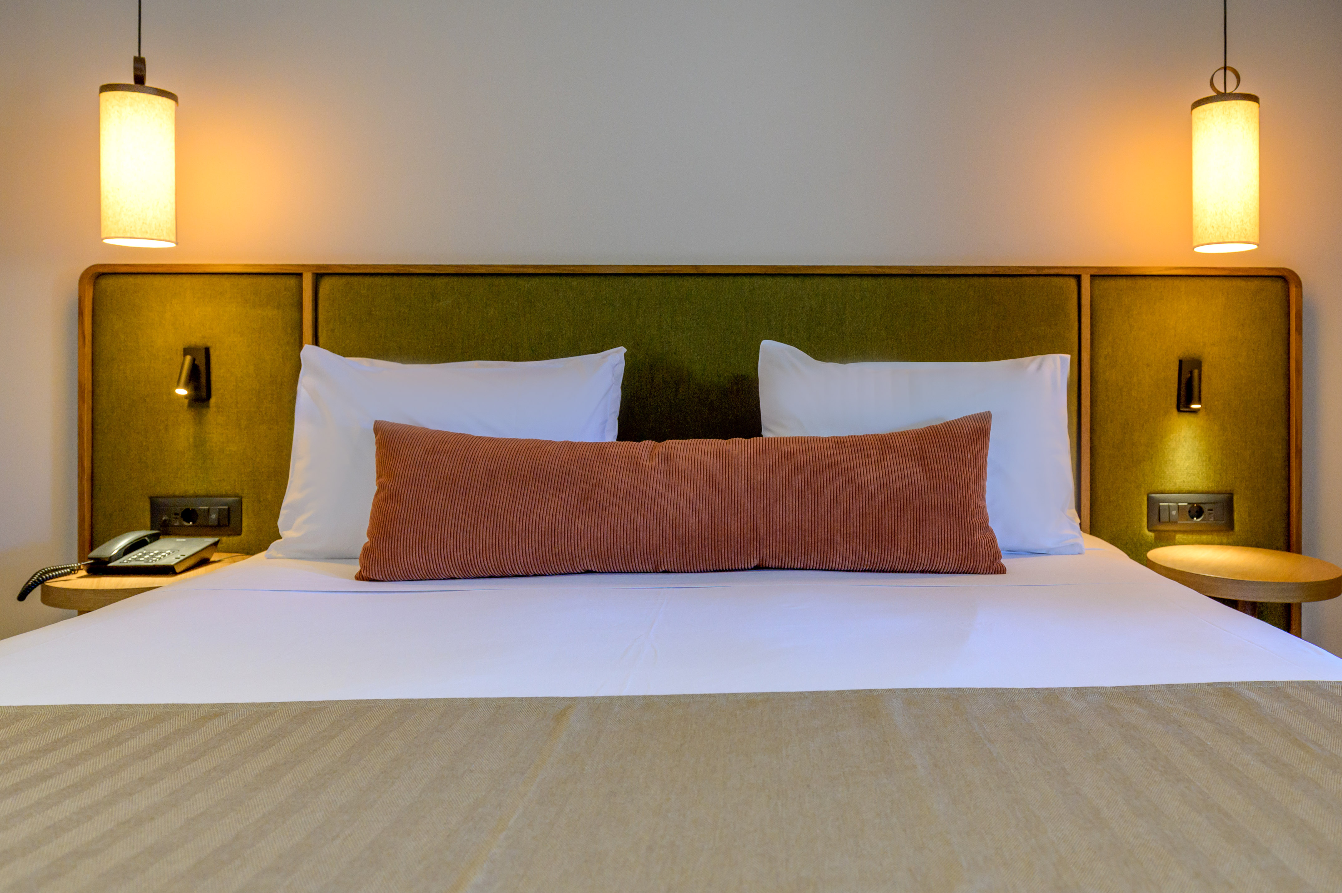 a bed with pillows and a green headboard