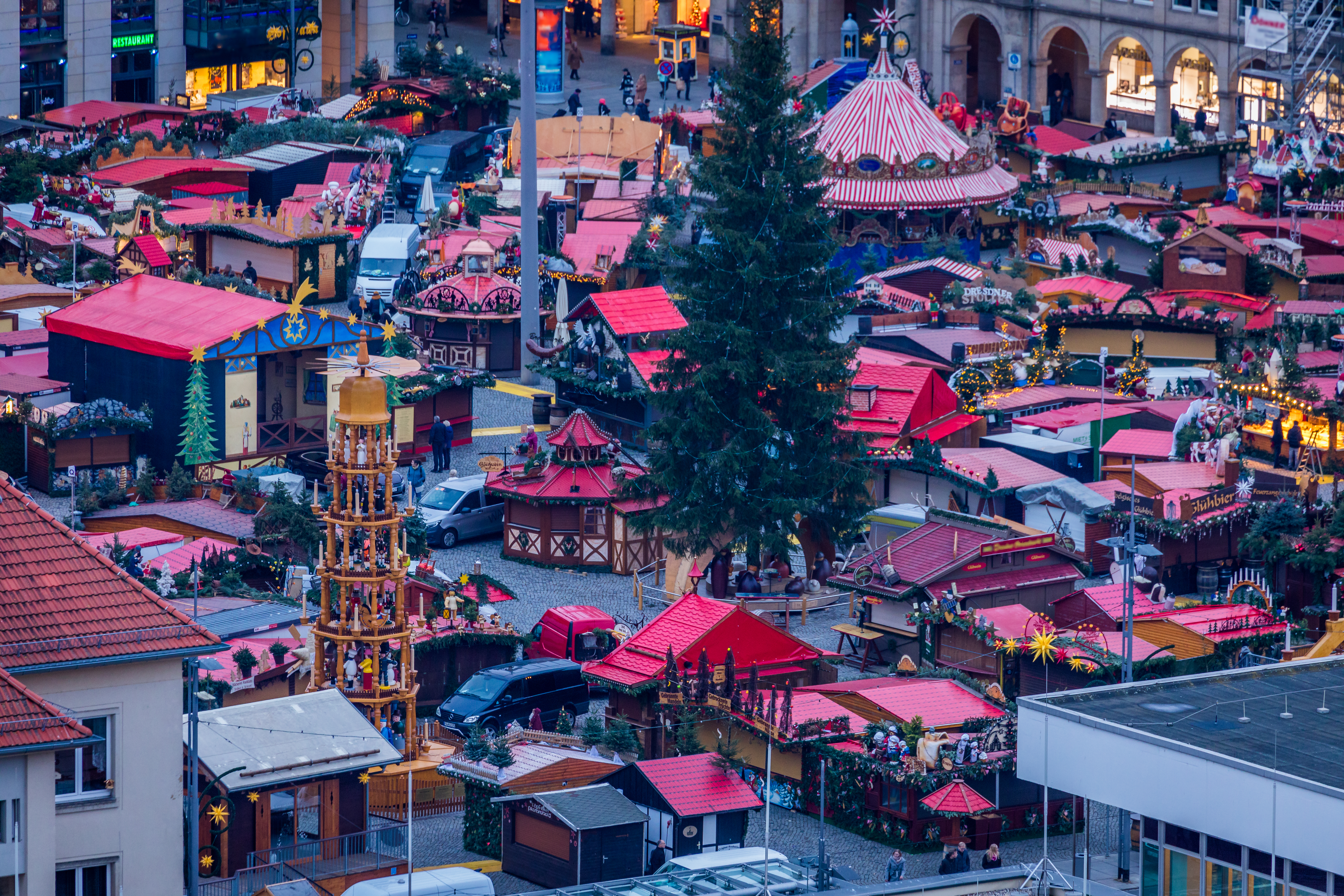 Dresden Christmas market with festive stalls, tall tree, carousel, and pyramid.