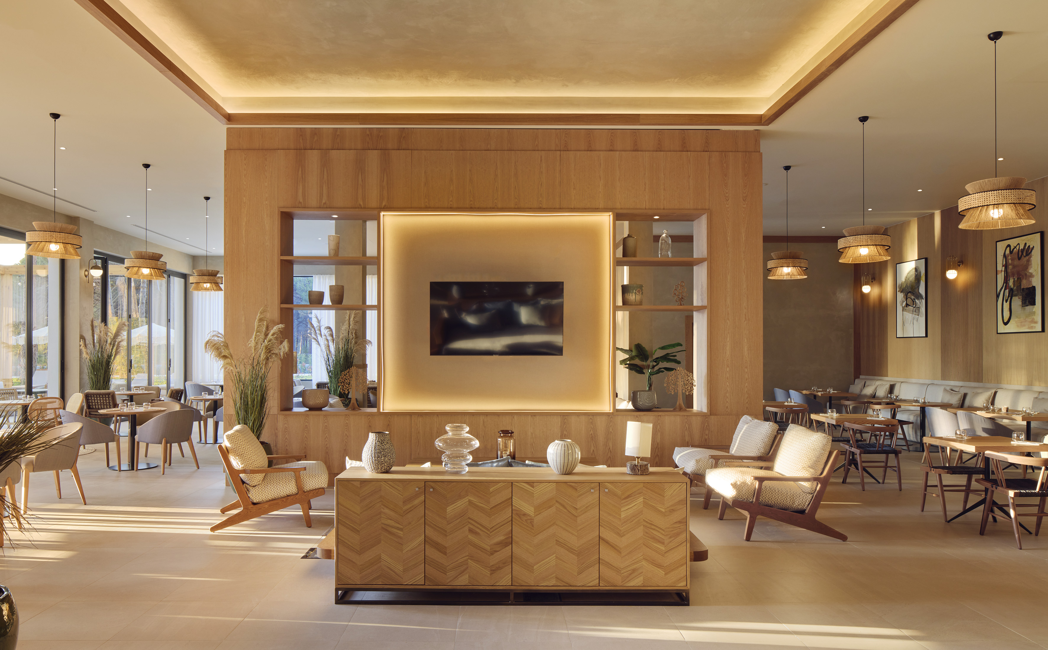 Modern resort interior with wood paneling, woven lights, and elegant seating.