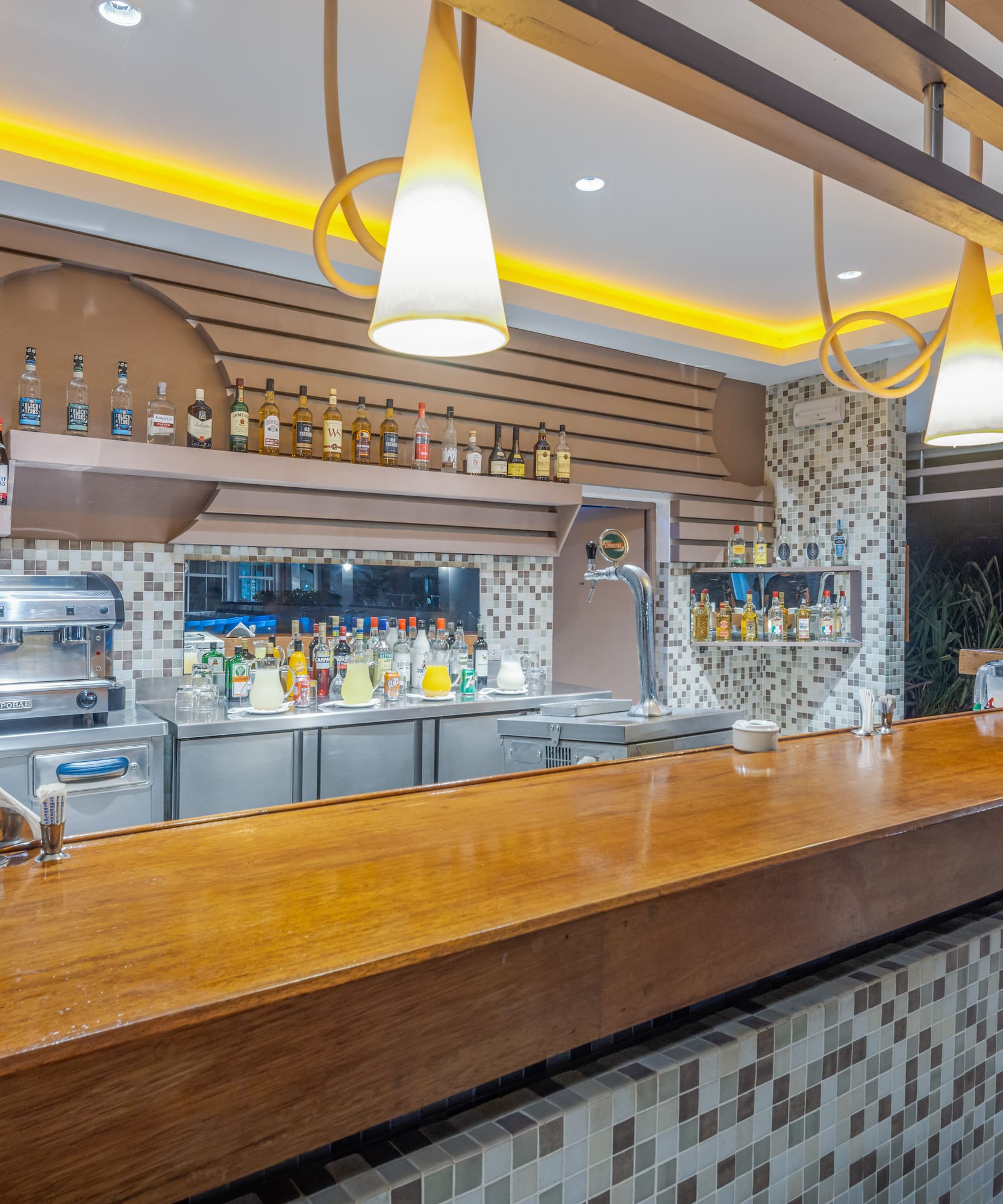 a bar with a counter and bottles of alcohol