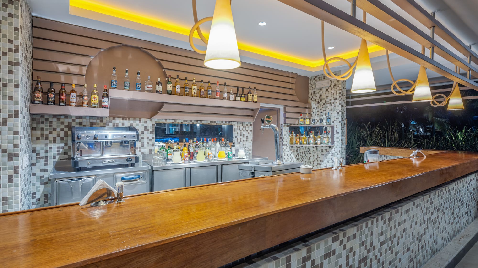 a bar with a counter and bottles of alcohol