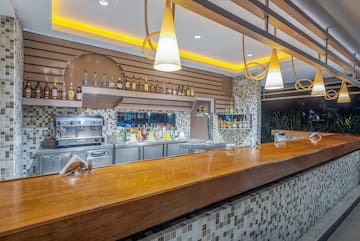 a bar with a counter and bottles of alcohol