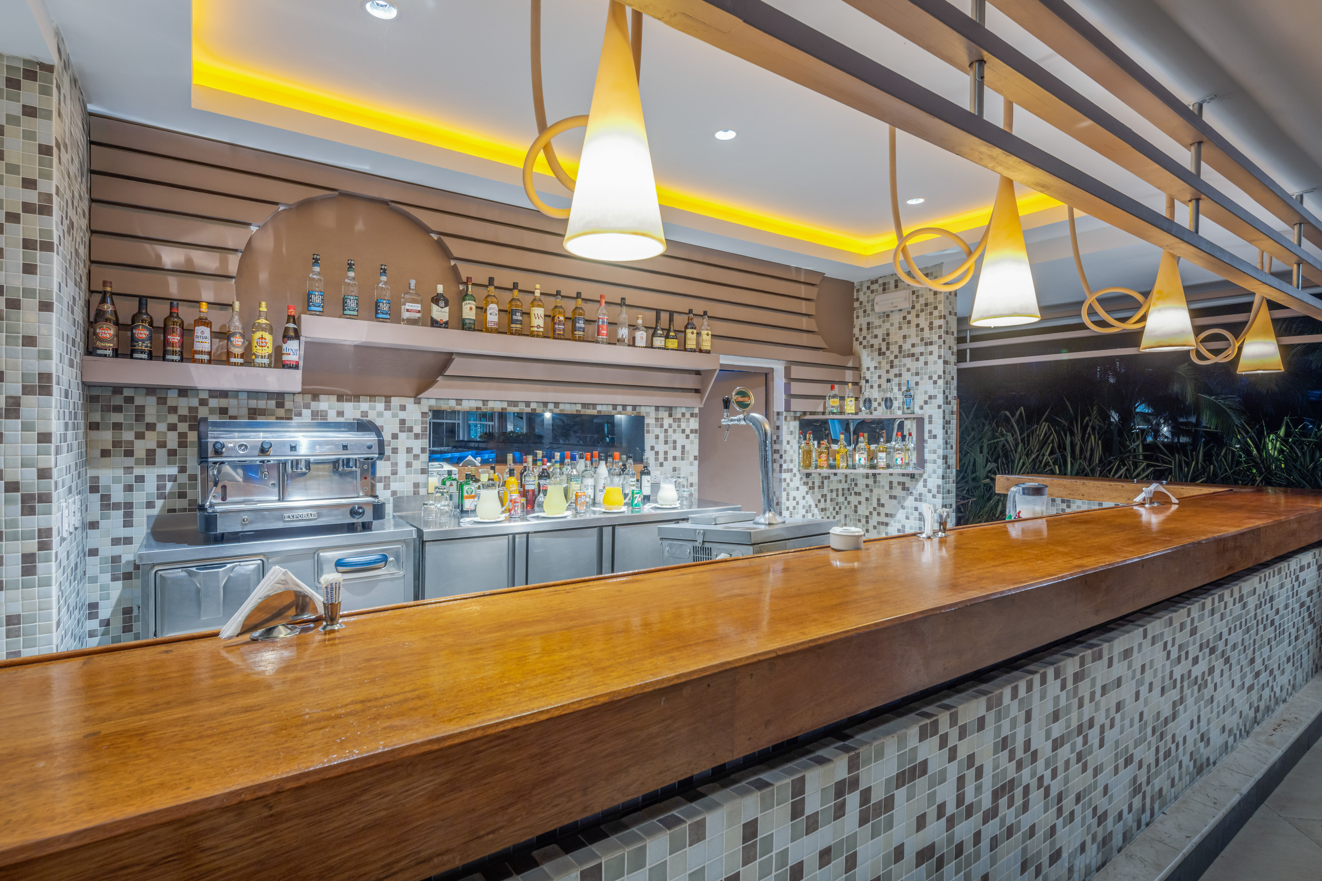 a bar with a counter and bottles of alcohol