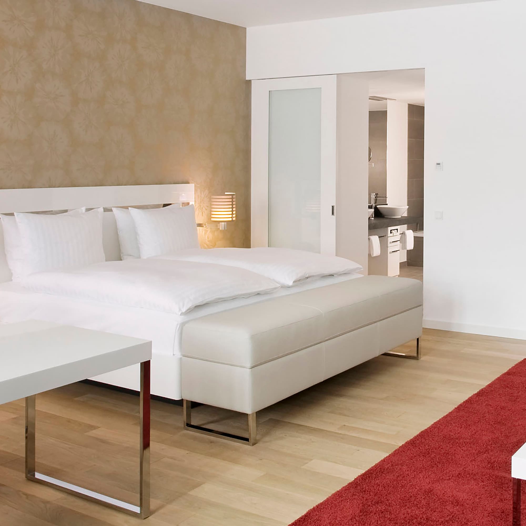 a bedroom with a bed and a red carpet