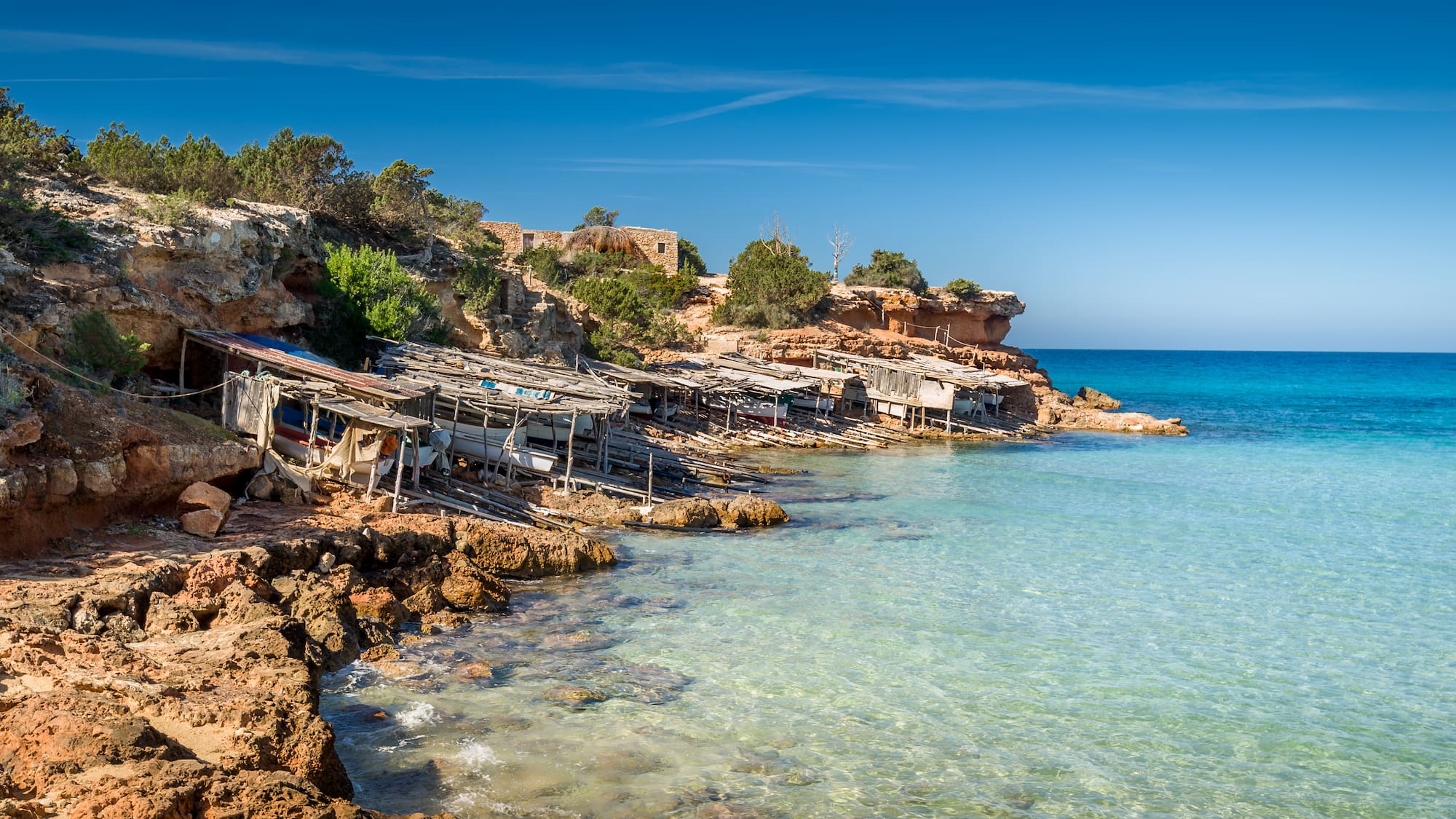 a rocky shore with a group of boats on it