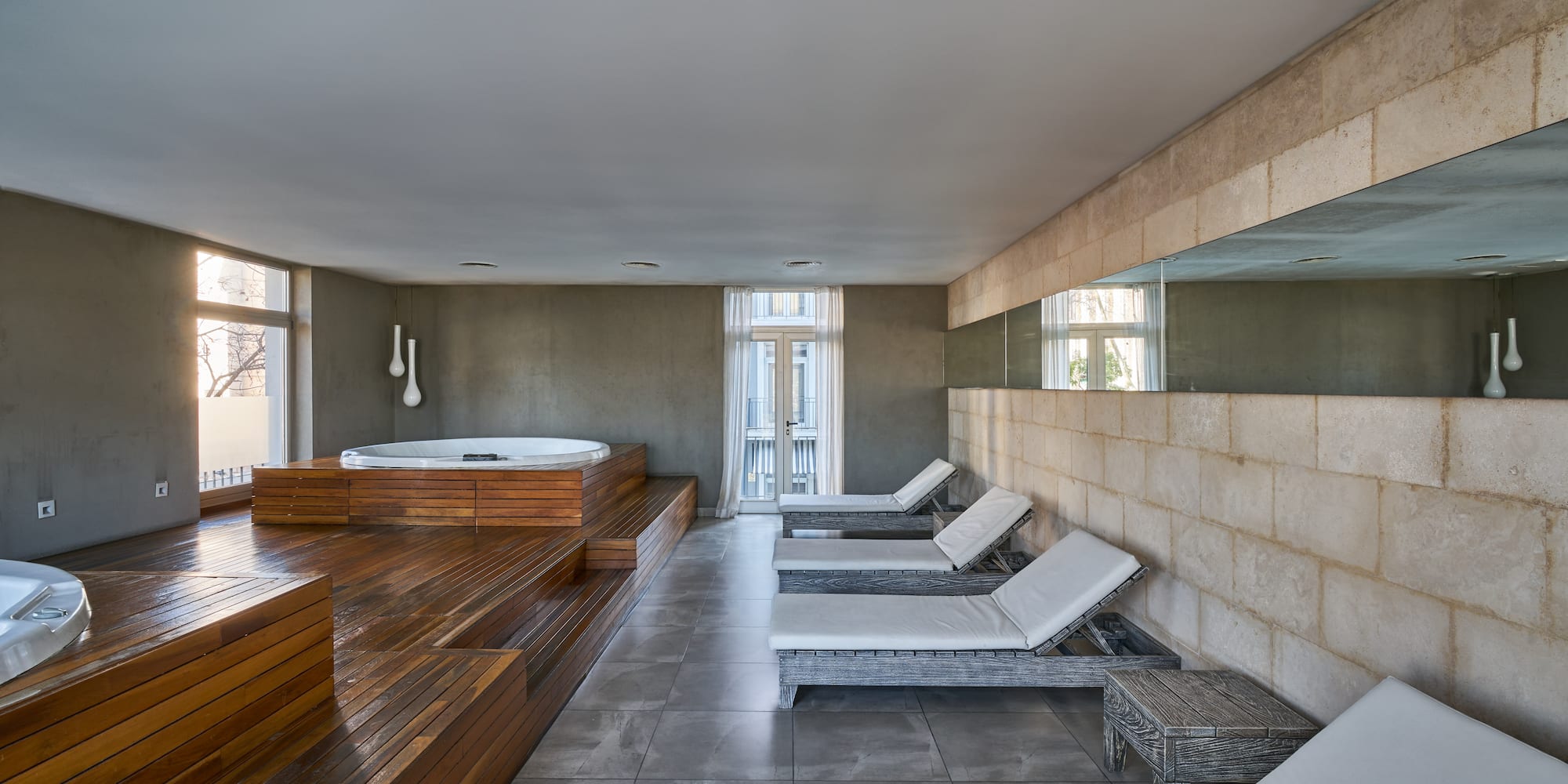 a room with a hot tub and chairs