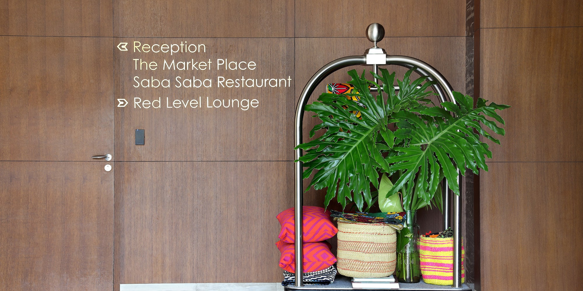 a cart with a plant and pillows in front of a door