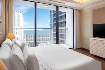 a bedroom with a large window overlooking a city