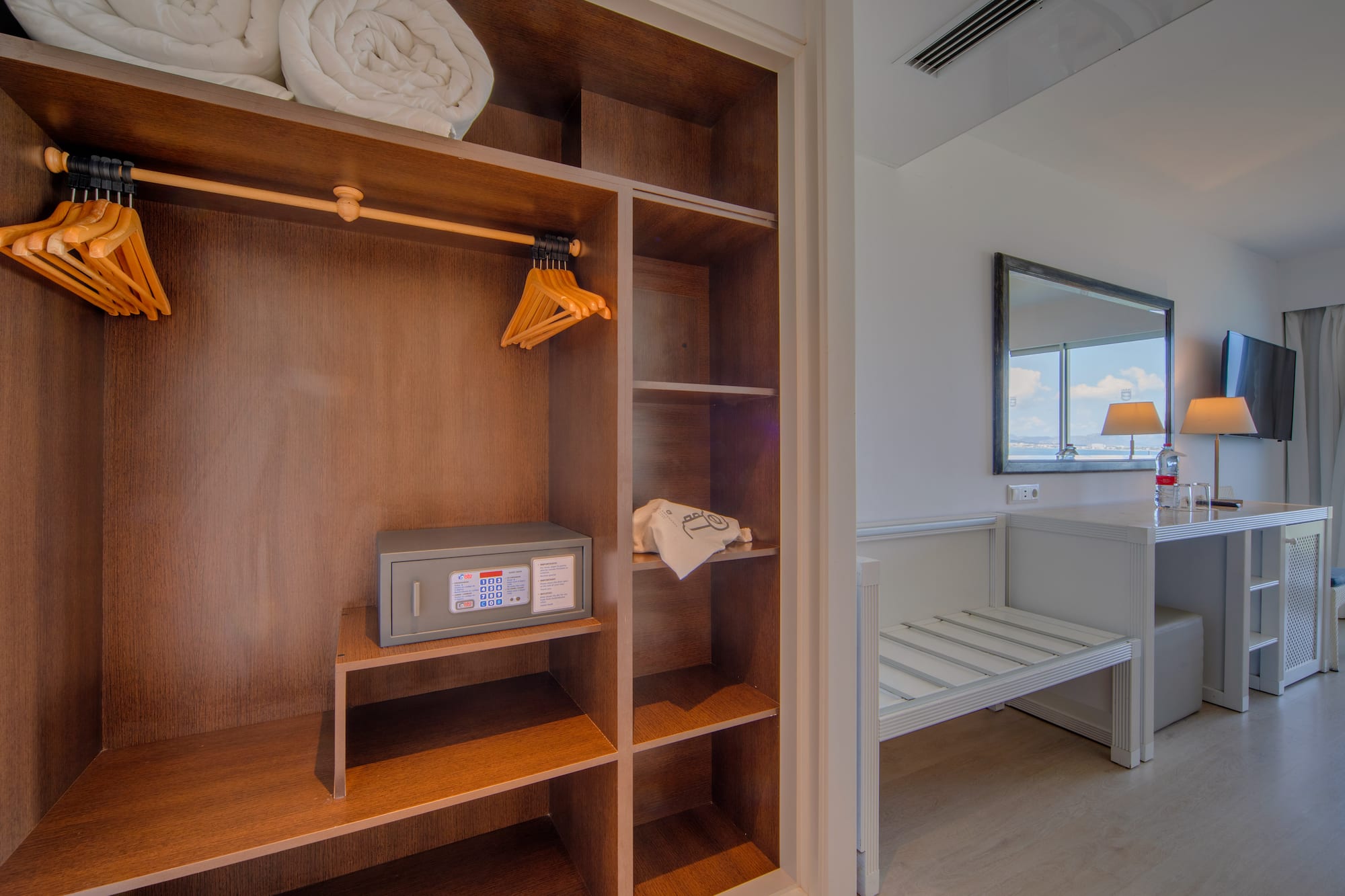 a closet with towels and a mirror
