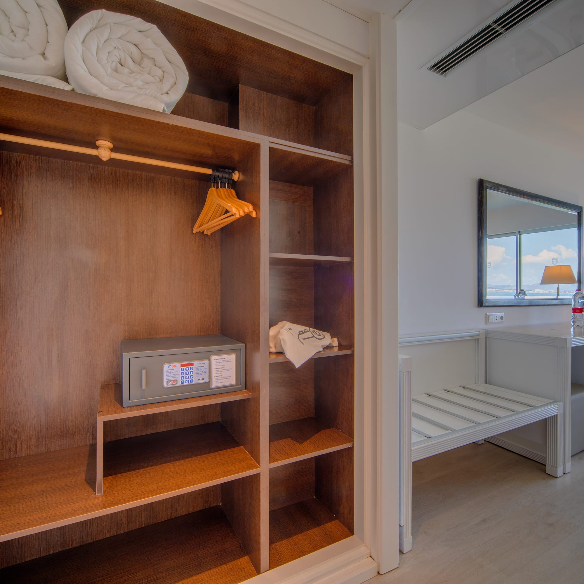 a closet with towels and a mirror