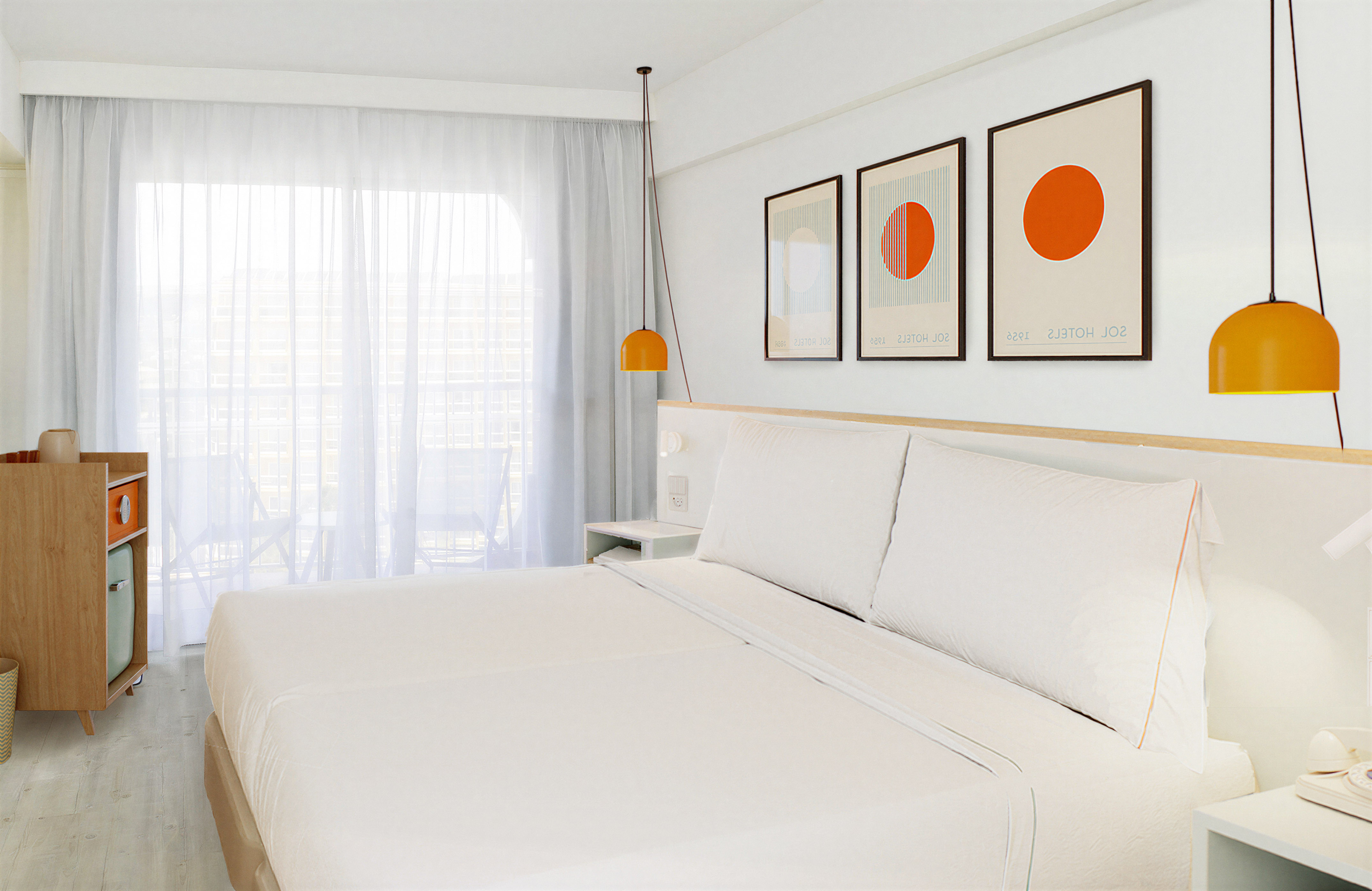 Bright hotel bedroom with white bed, orange pendant lamps, and geometric art.