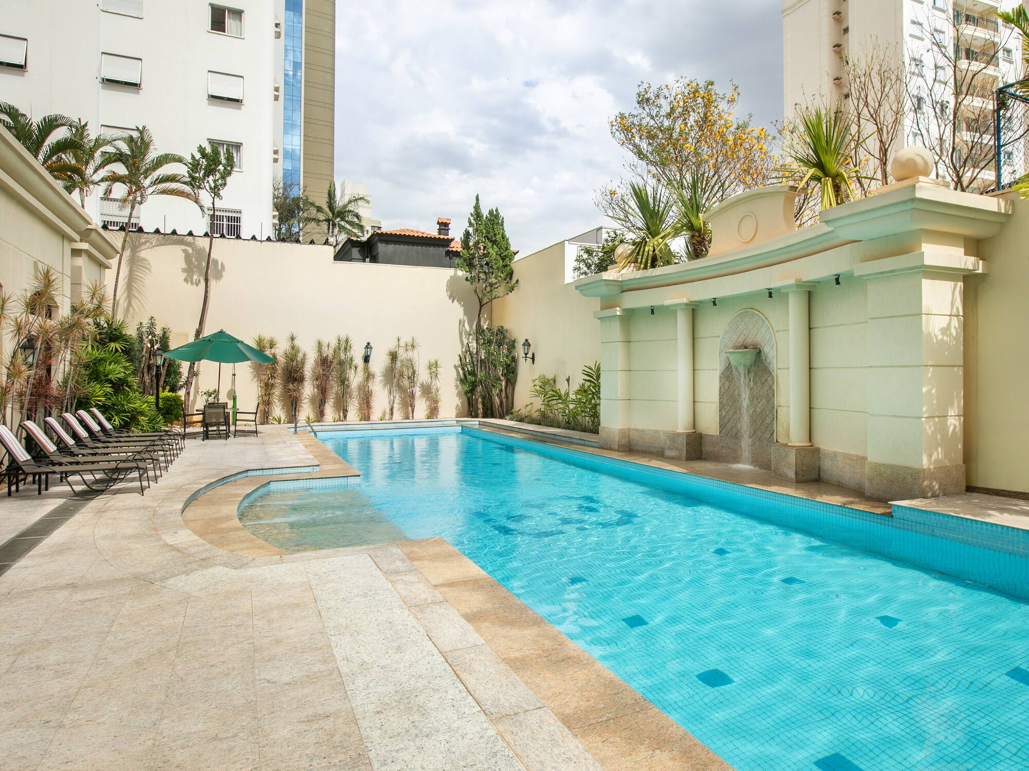 a swimming pool with a fountain in the middle of it