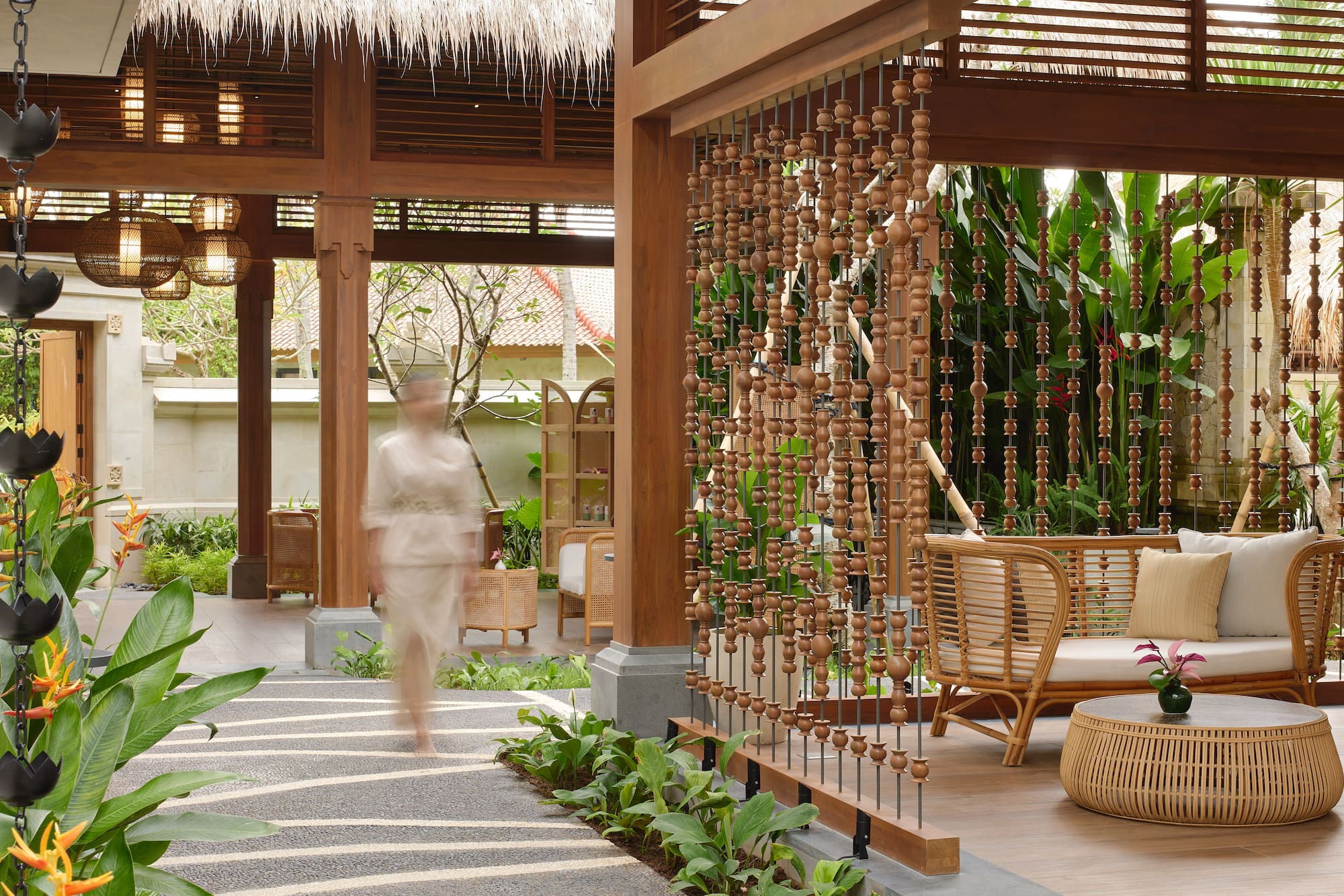 a person walking in a room with a wooden curtain