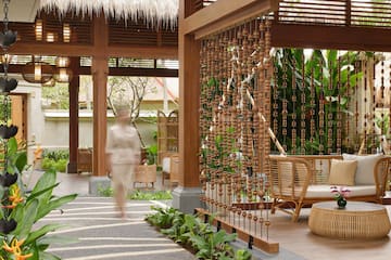 a person walking in a room with a wooden curtain