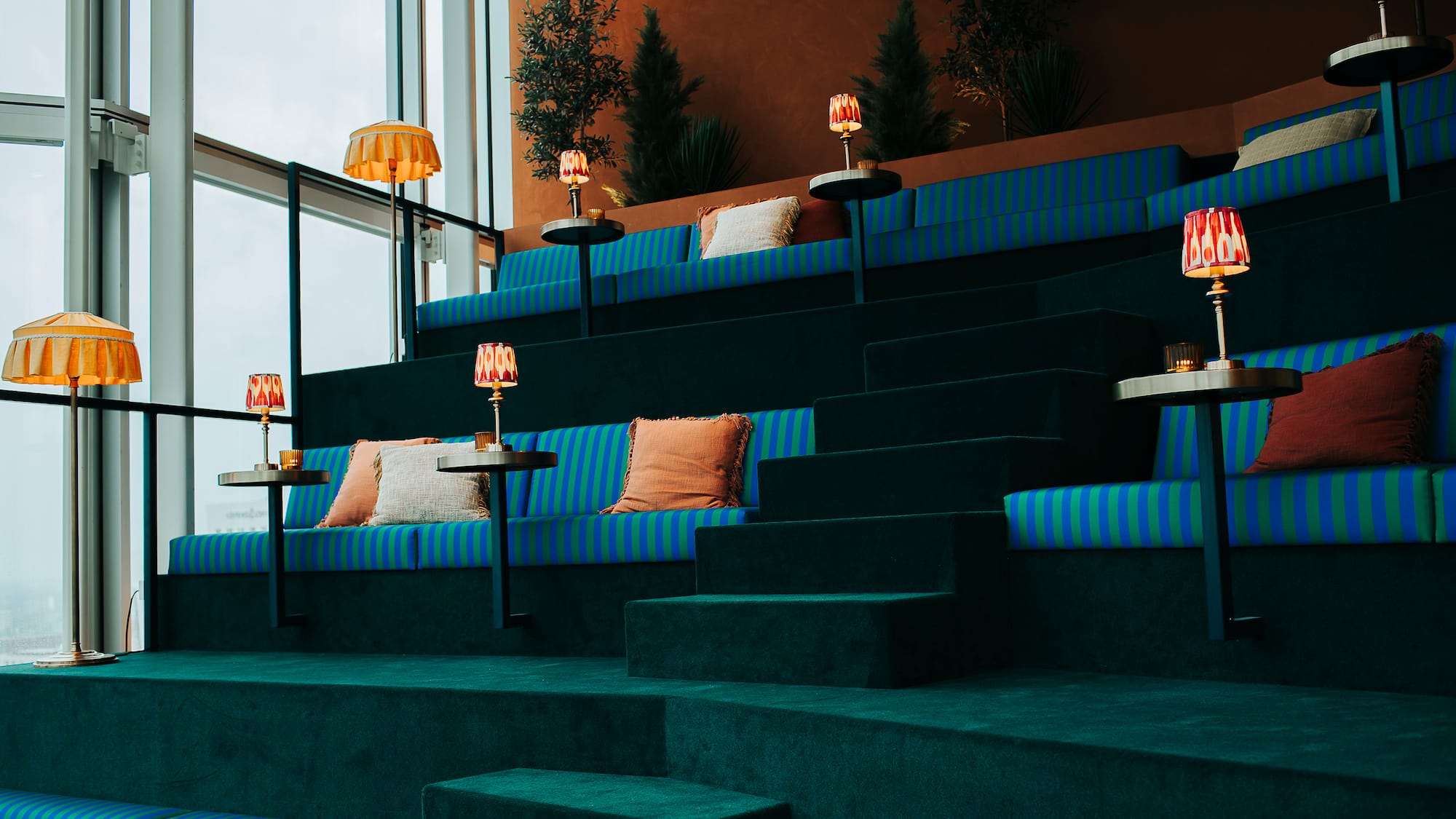 a blue and green striped seating in a room with a large window