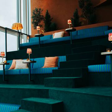 a blue and green striped seating in a room with a large window