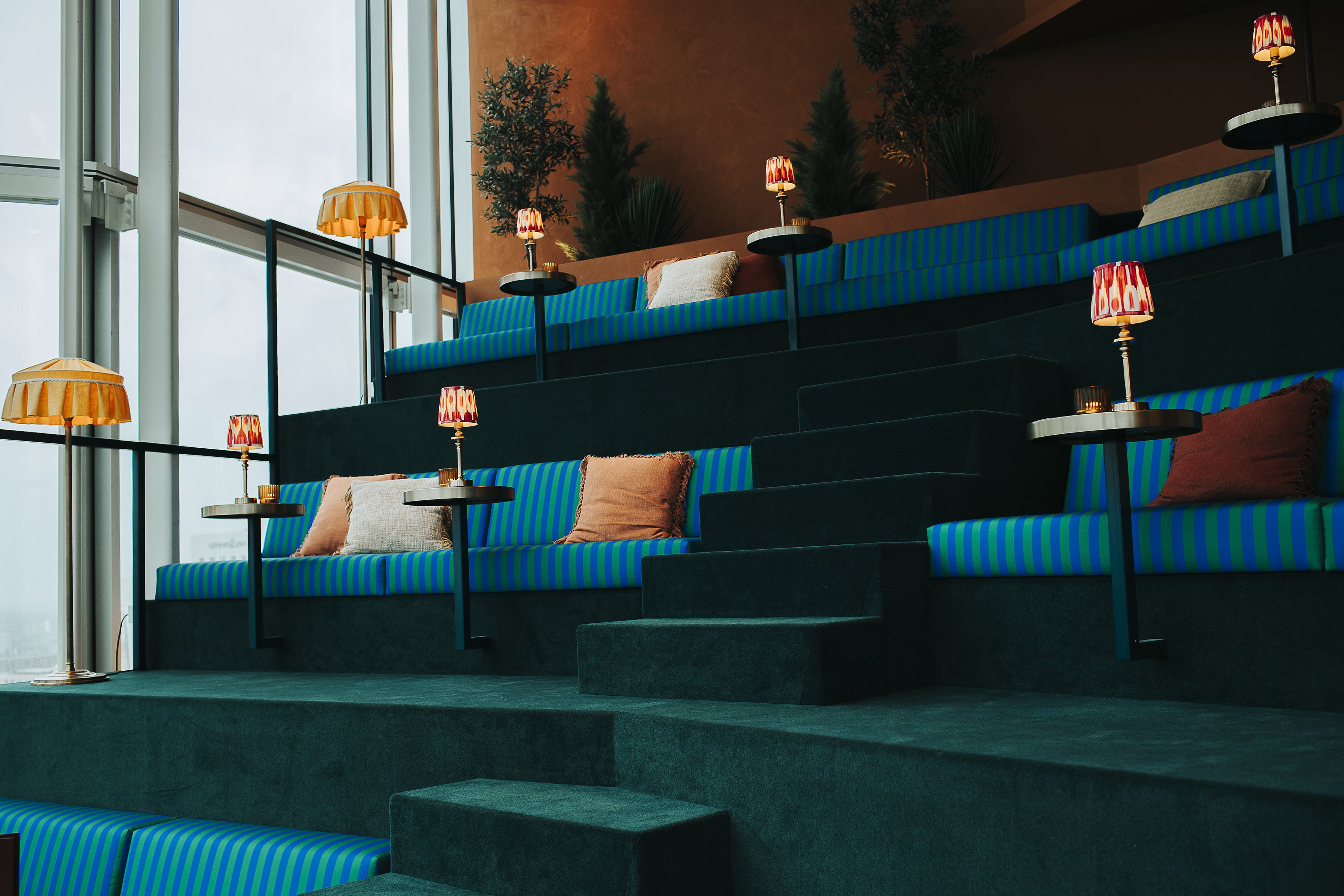 a blue and green striped seating in a room with a large window