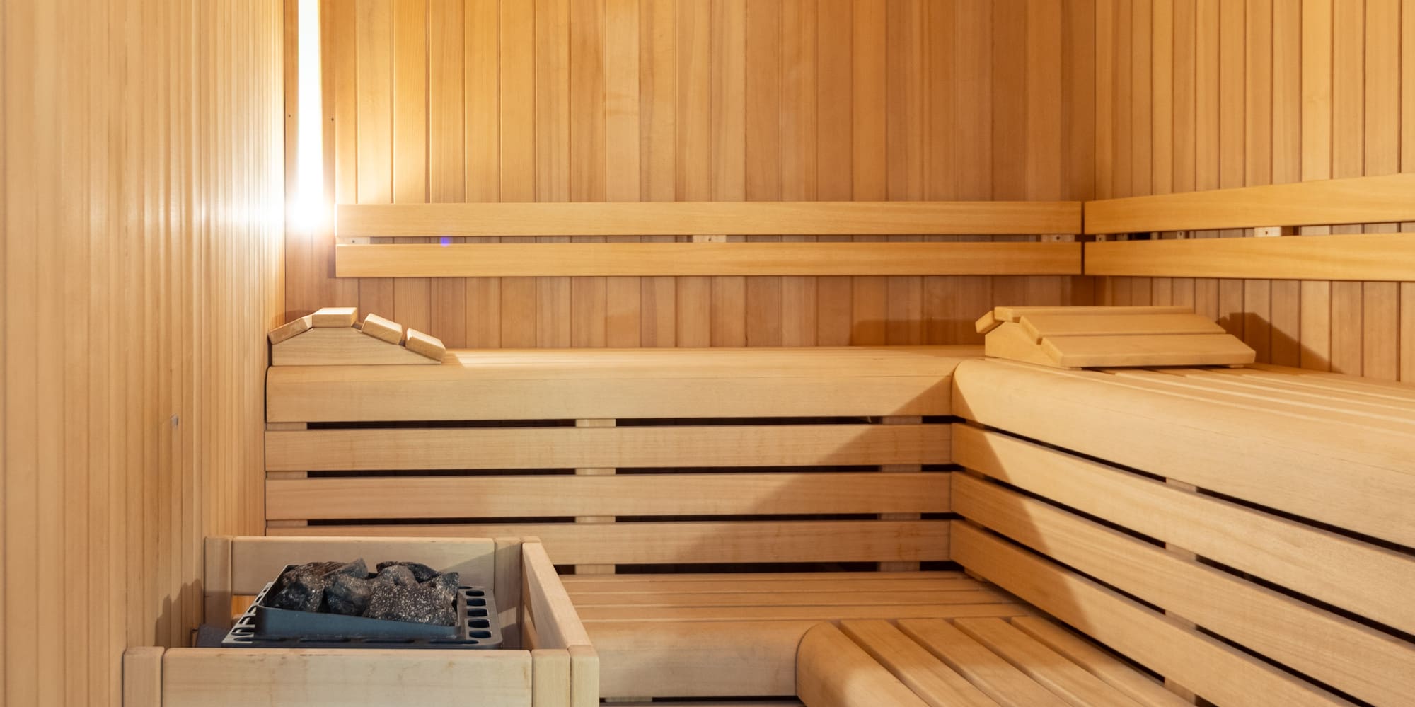 a wooden sauna with a basket and a fire in it