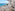 Luxury banquet hall with set tables, floral decor, and panoramic ocean views.
