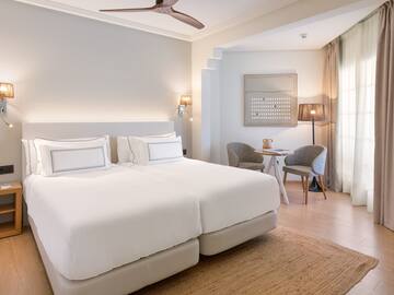 a room with a bed and a table and chairs