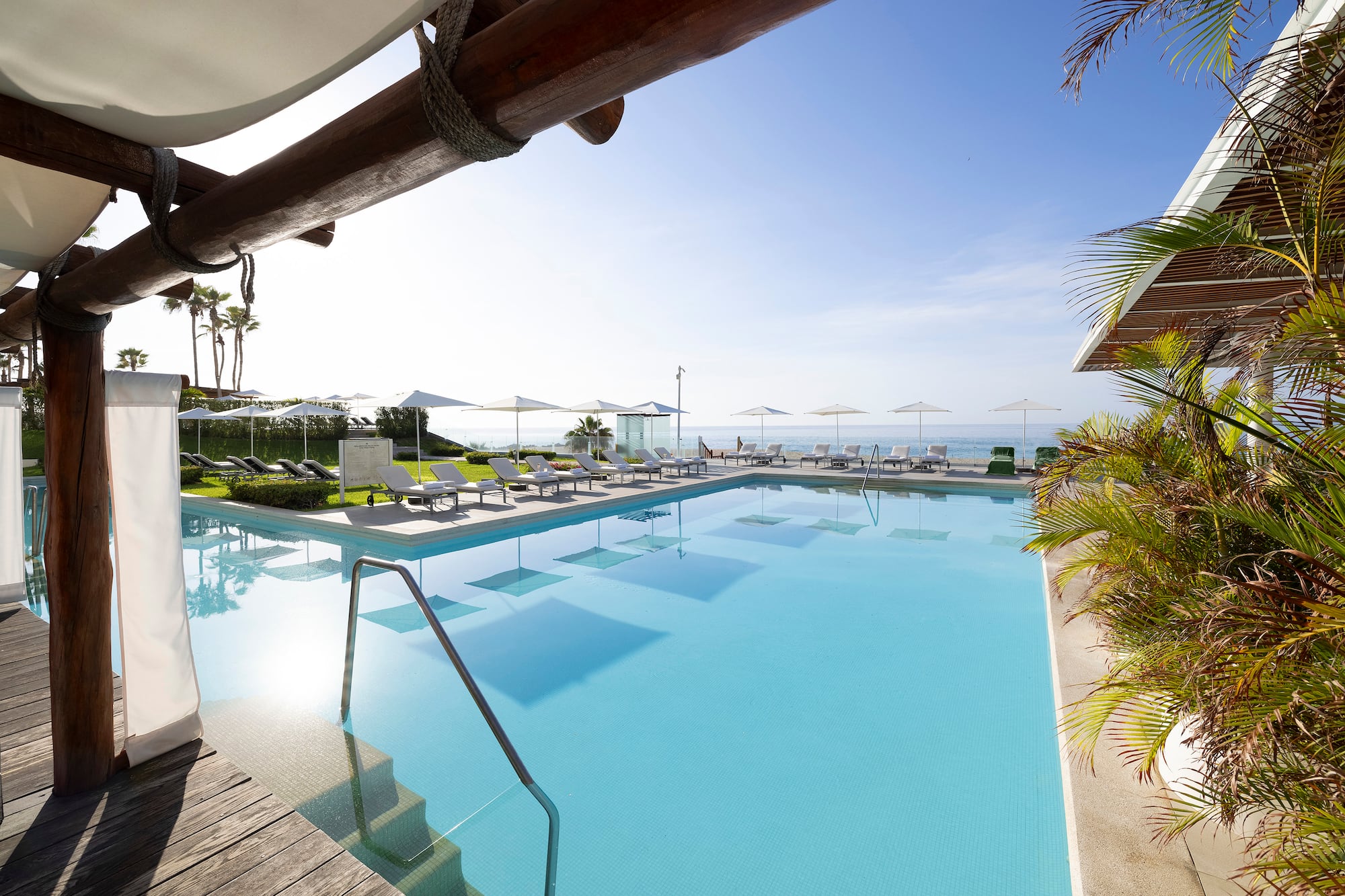 a pool with chairs and umbrellas
