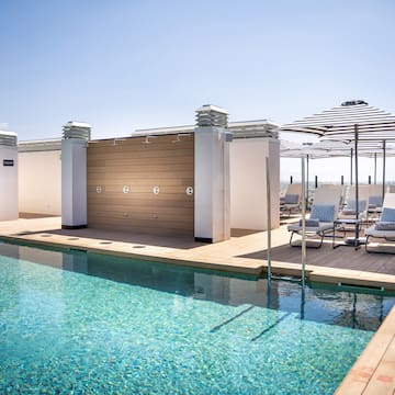 a pool with chairs and umbrellas