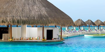 a pool with a thatched roof and a bar