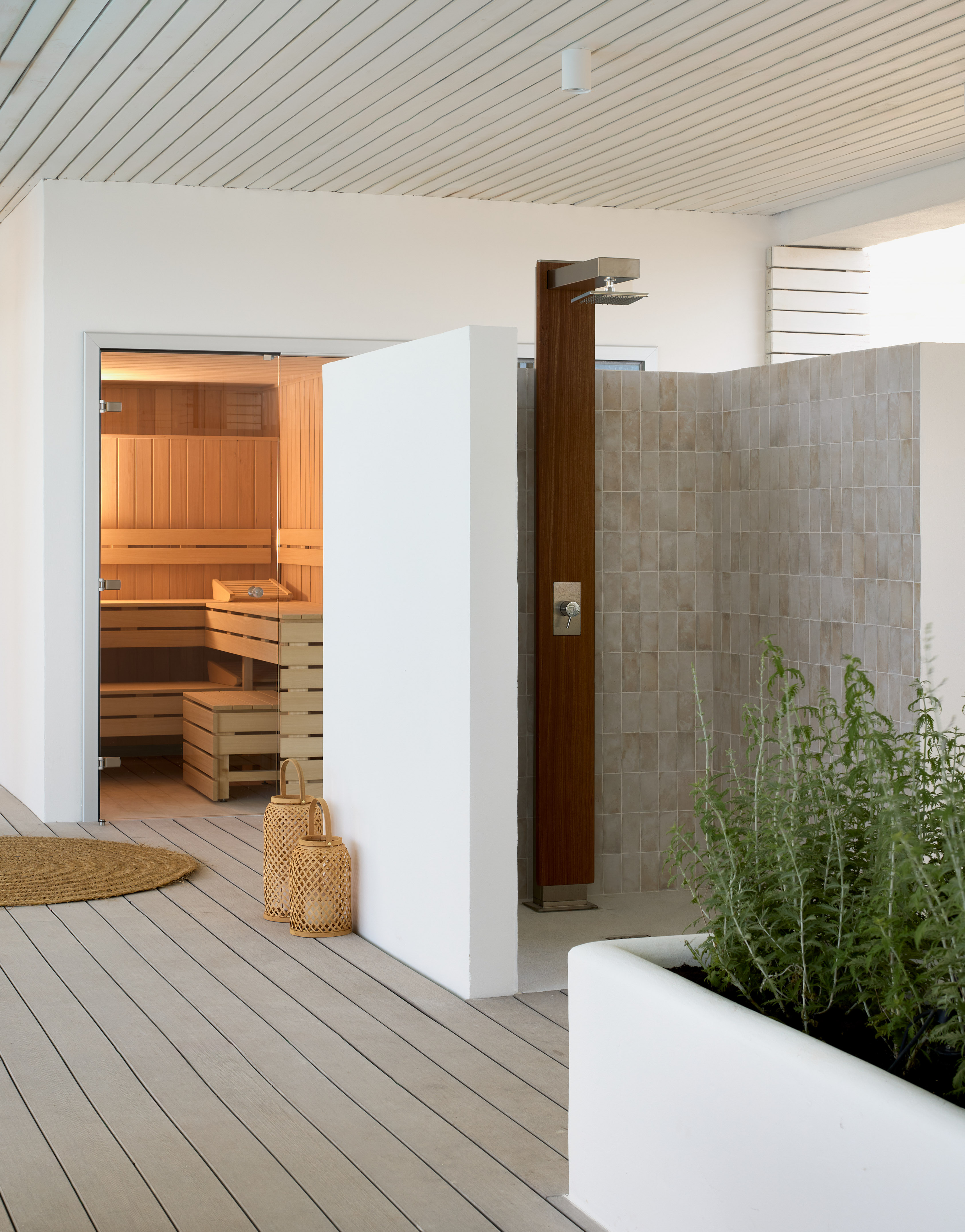 Contemporary outdoor spa area with a sauna, shower, and wooden deck.
