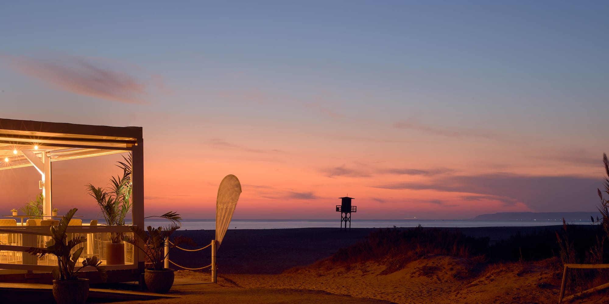 a beach with a structure and a lifeguard tower