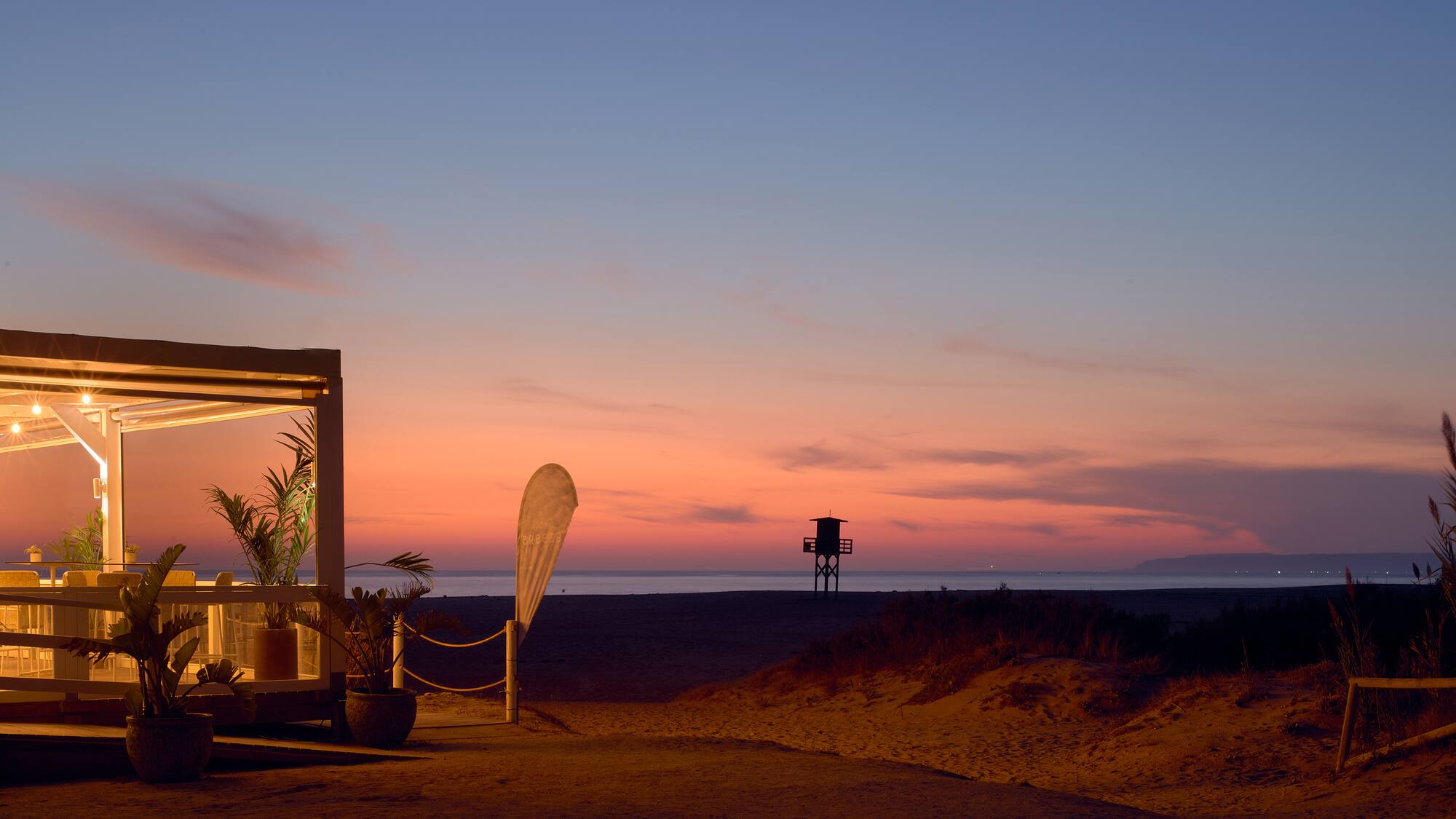 a beach with a structure and a lifeguard tower