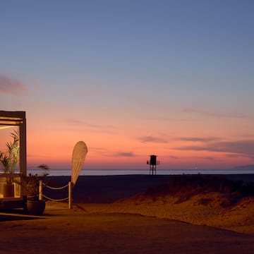 a beach with a structure and a lifeguard tower