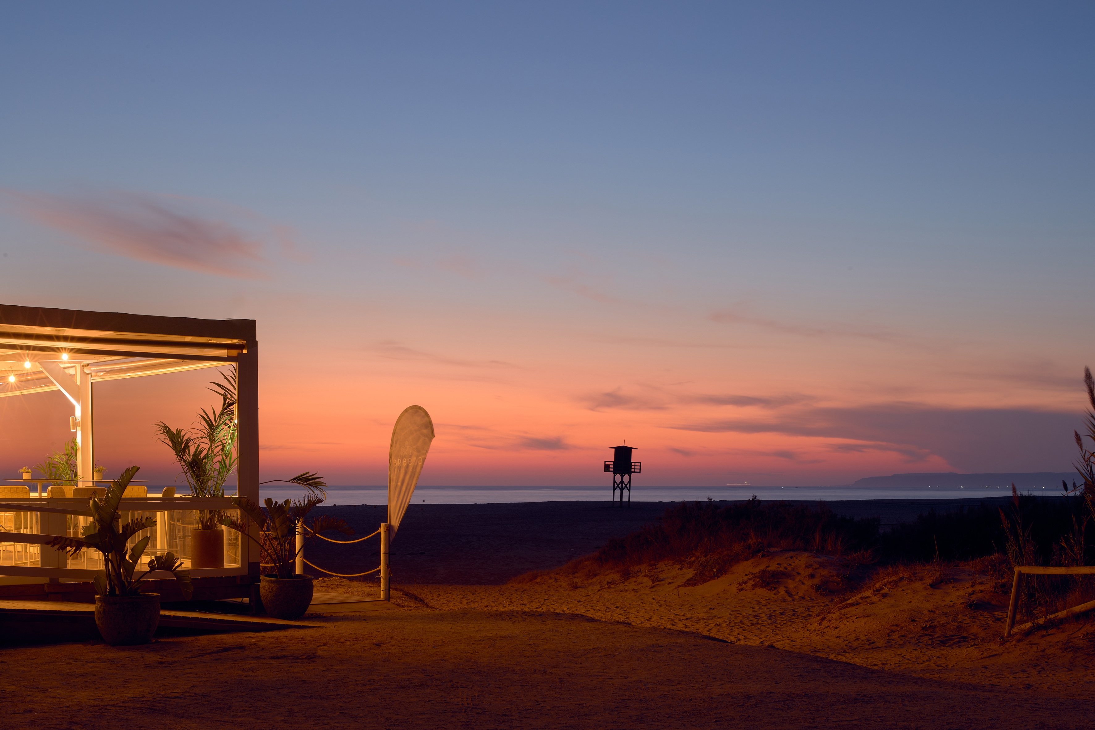 a beach with a structure and a lifeguard tower