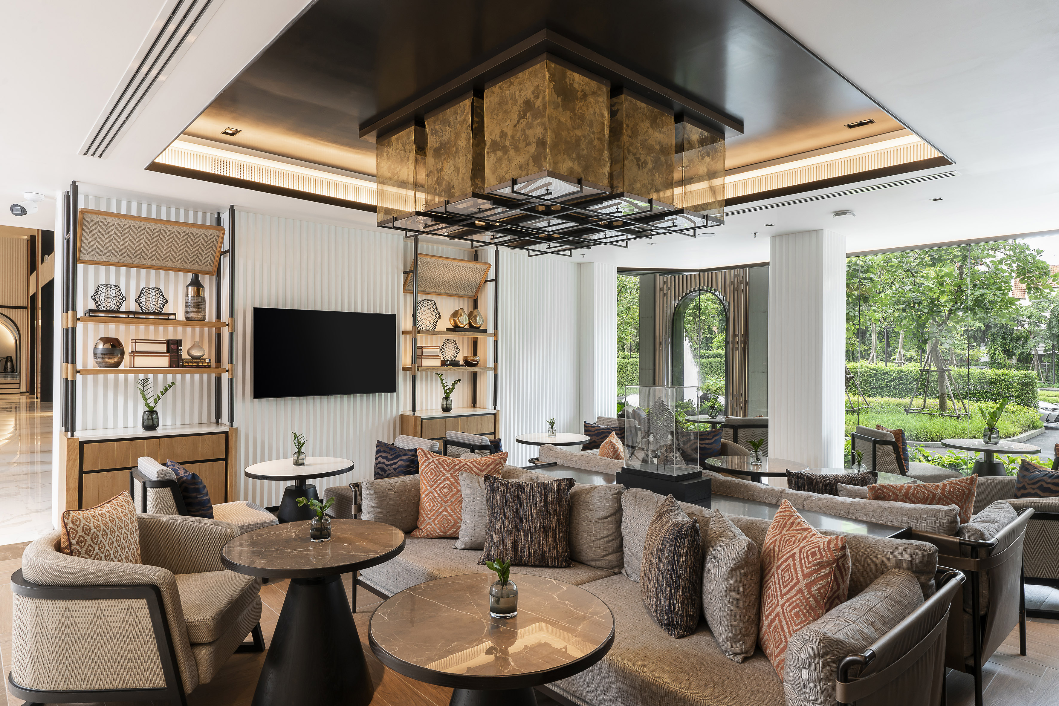 Modern luxury lounge with comfortable sofas, decorative lighting, and garden view.