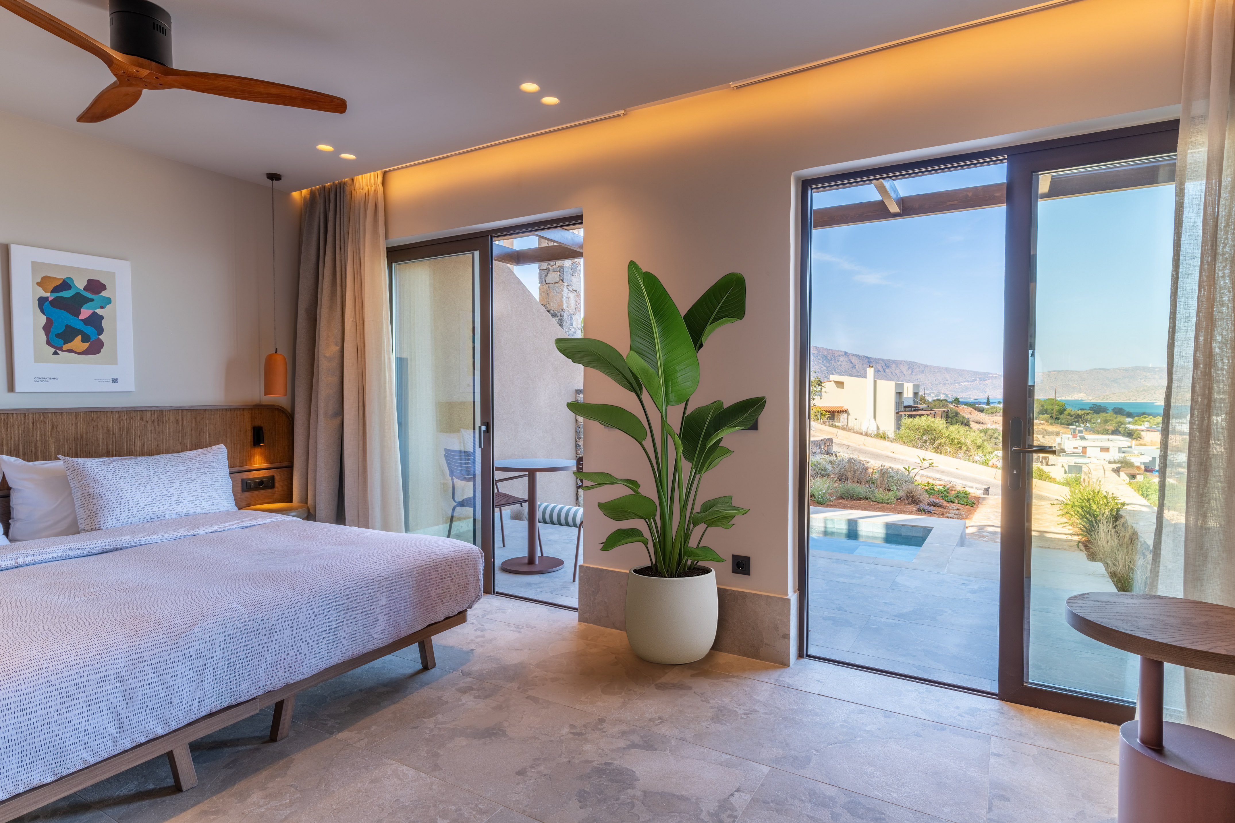 Modern hotel bedroom with sea view, private terrace, and sleek design.