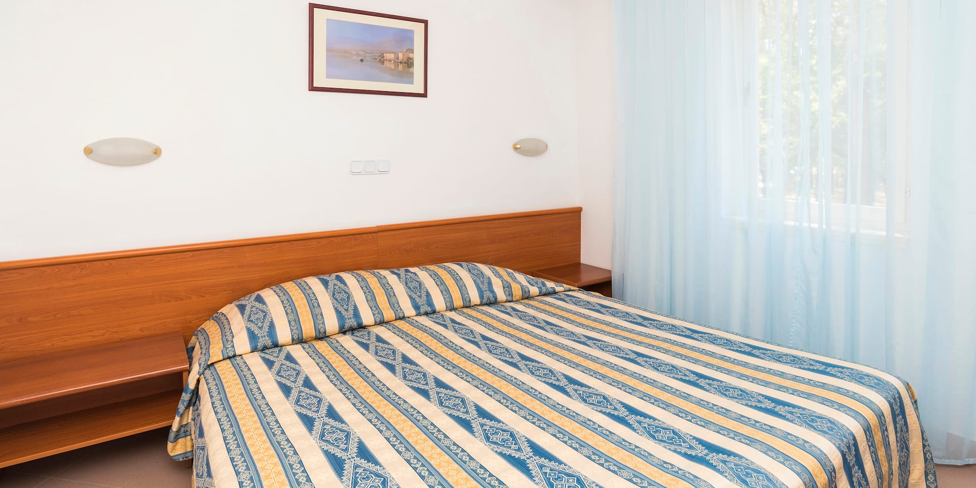 a bed with a wood headboard and a lamp in a room