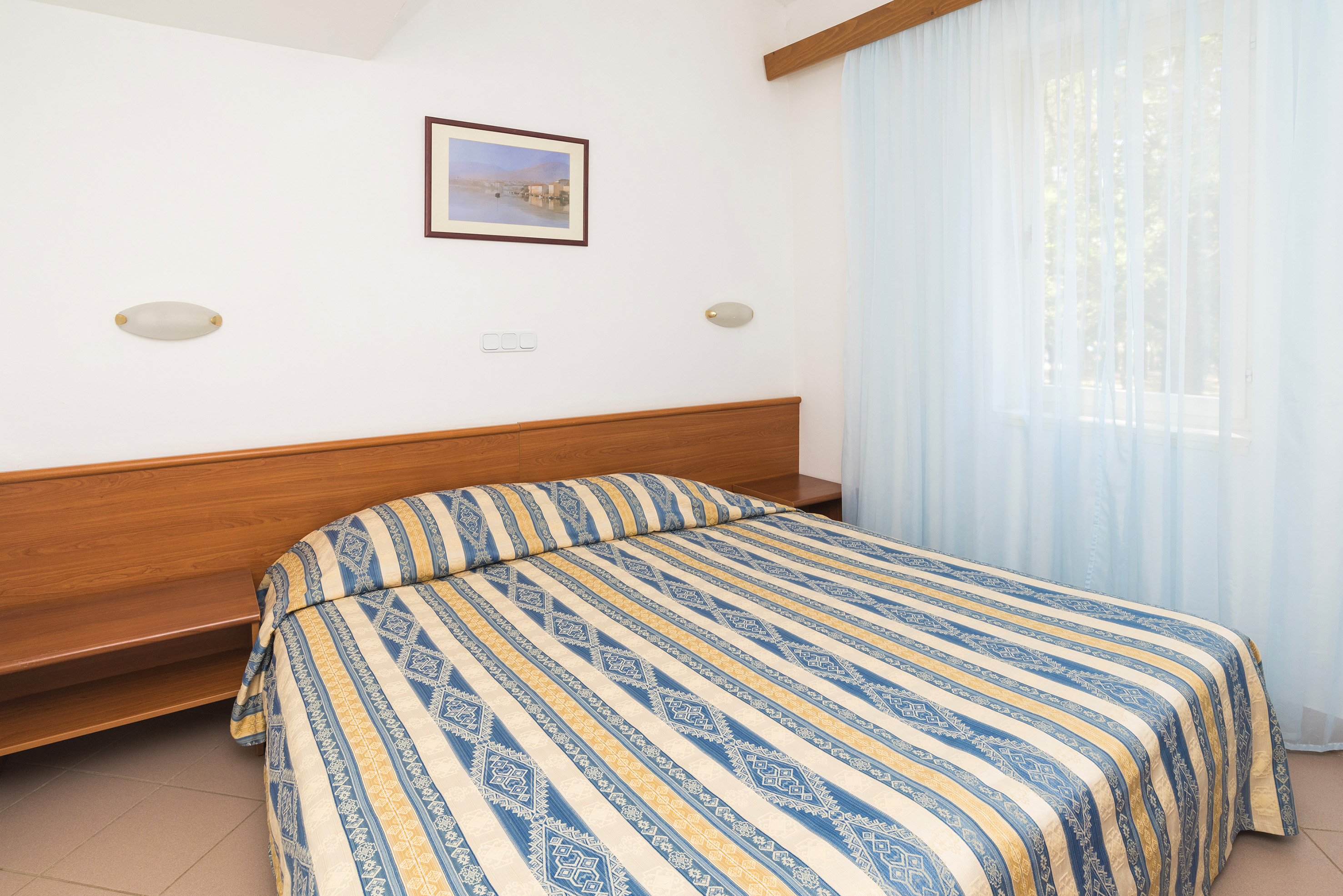 a bed with a wood headboard and a lamp in a room