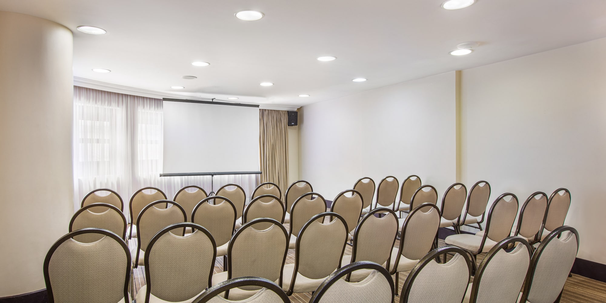 a room with chairs and a projector screen