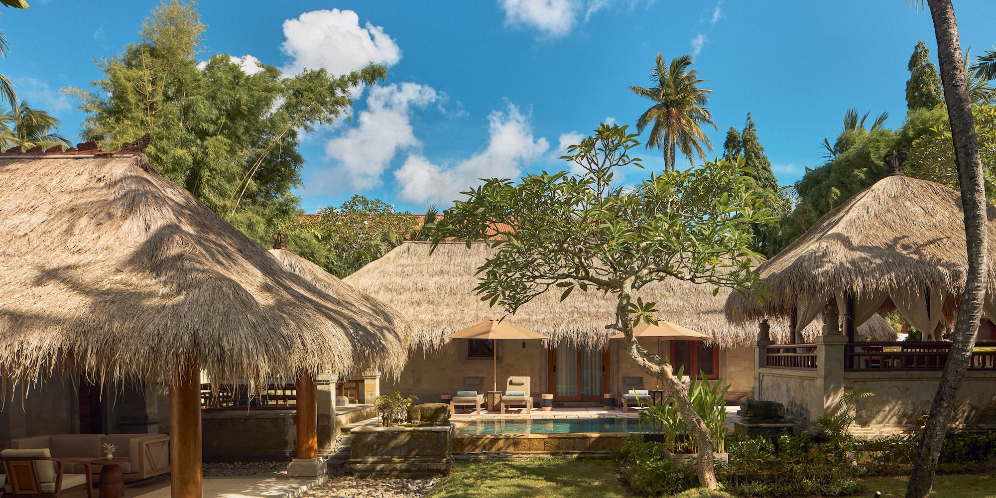 a building with grass roofs and a pool