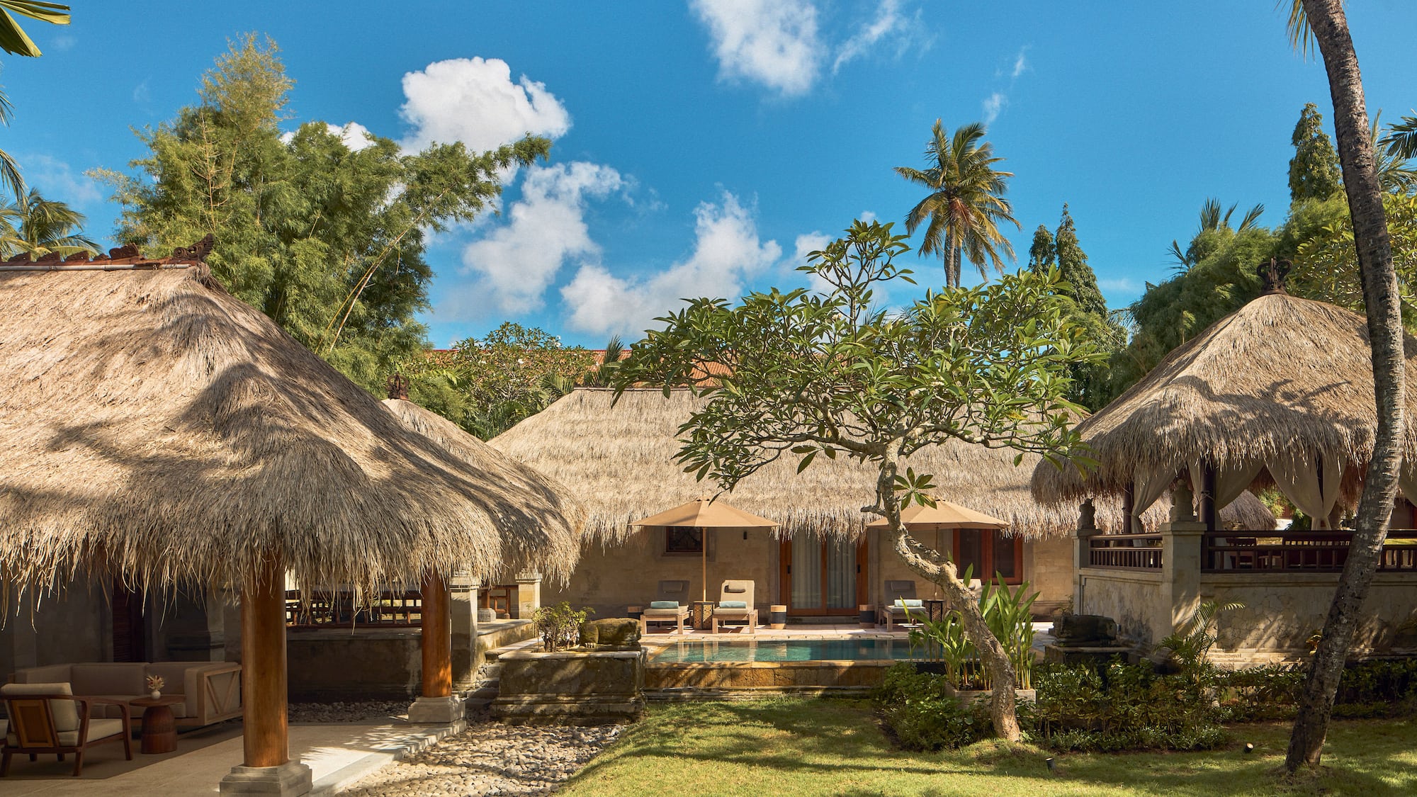 a building with grass roofs and a pool