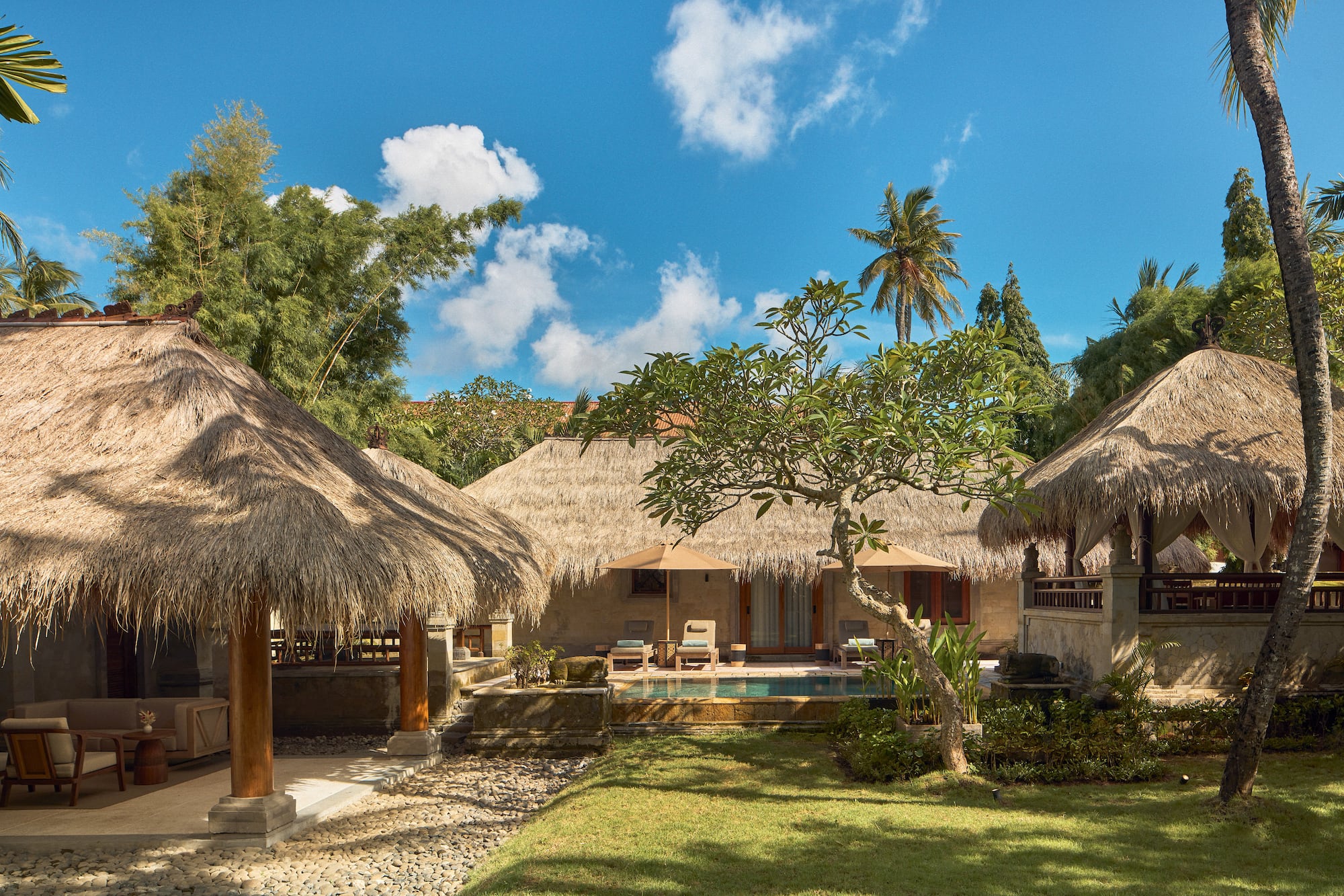 a building with grass roofs and a pool