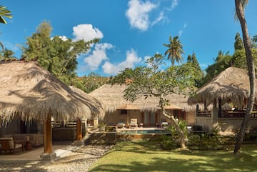 a building with grass roofs and a pool