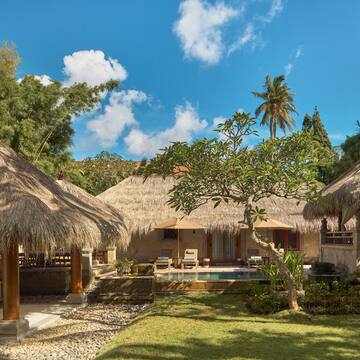 a building with grass roofs and a pool