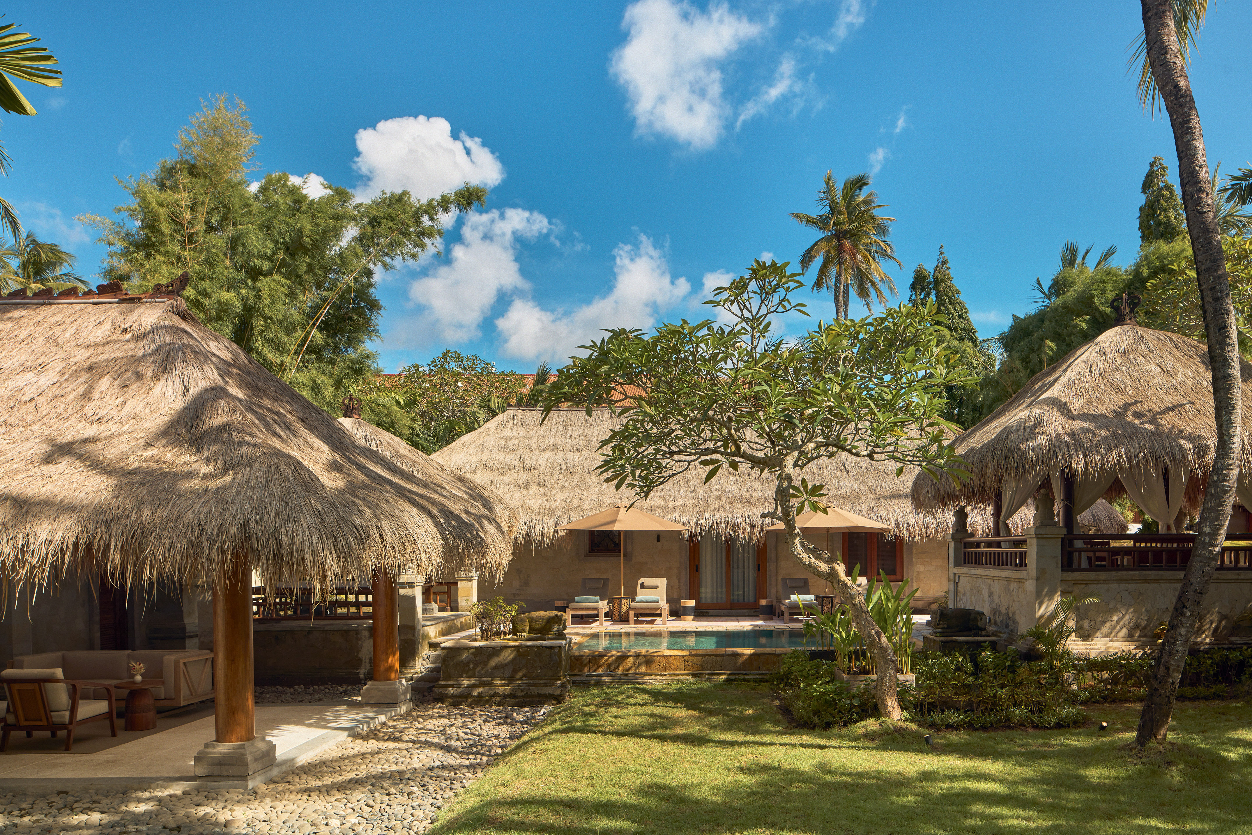 a building with grass roofs and a pool