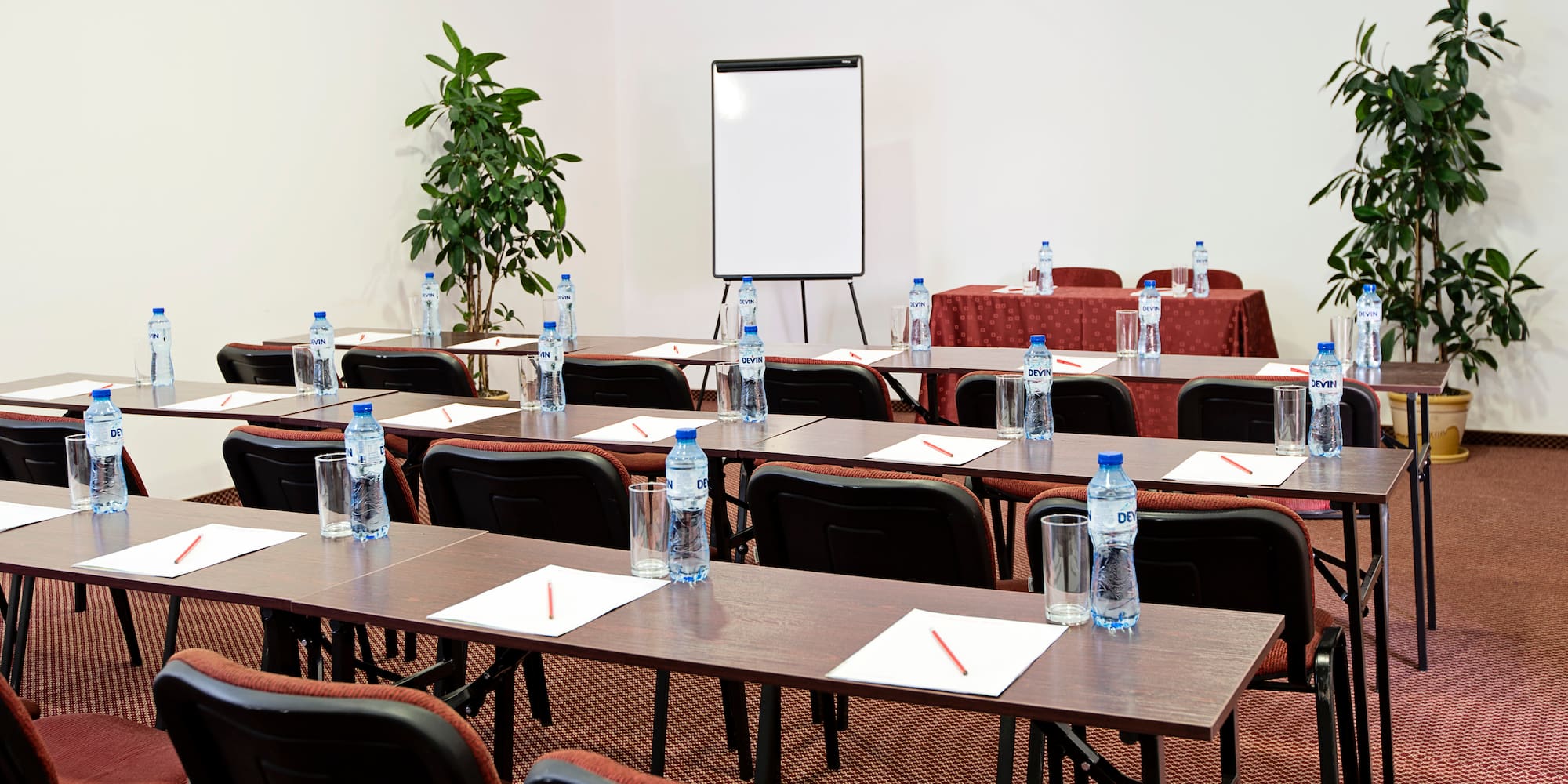 a room with tables and chairs and a white board