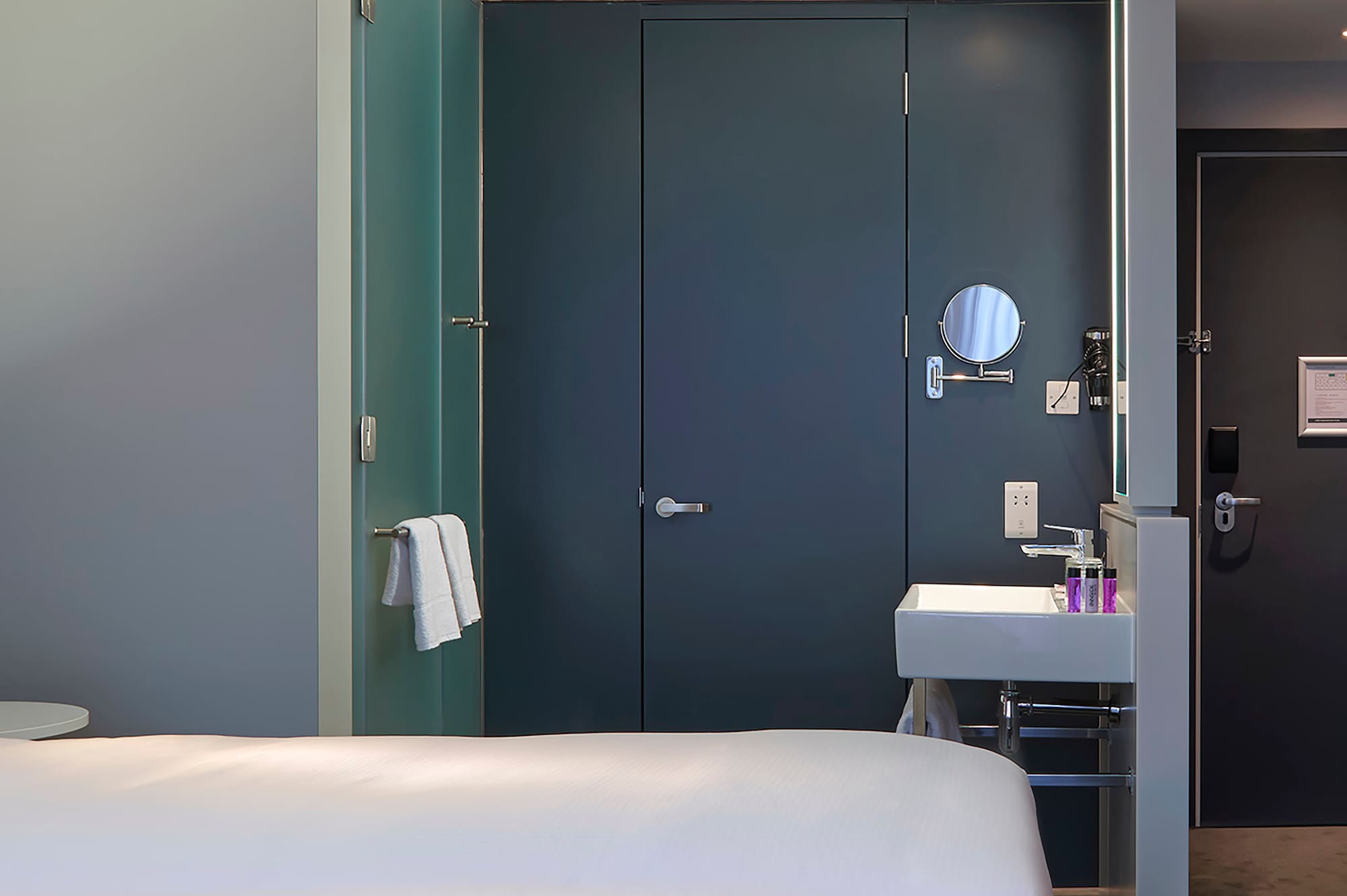 a room with two beds and a sink