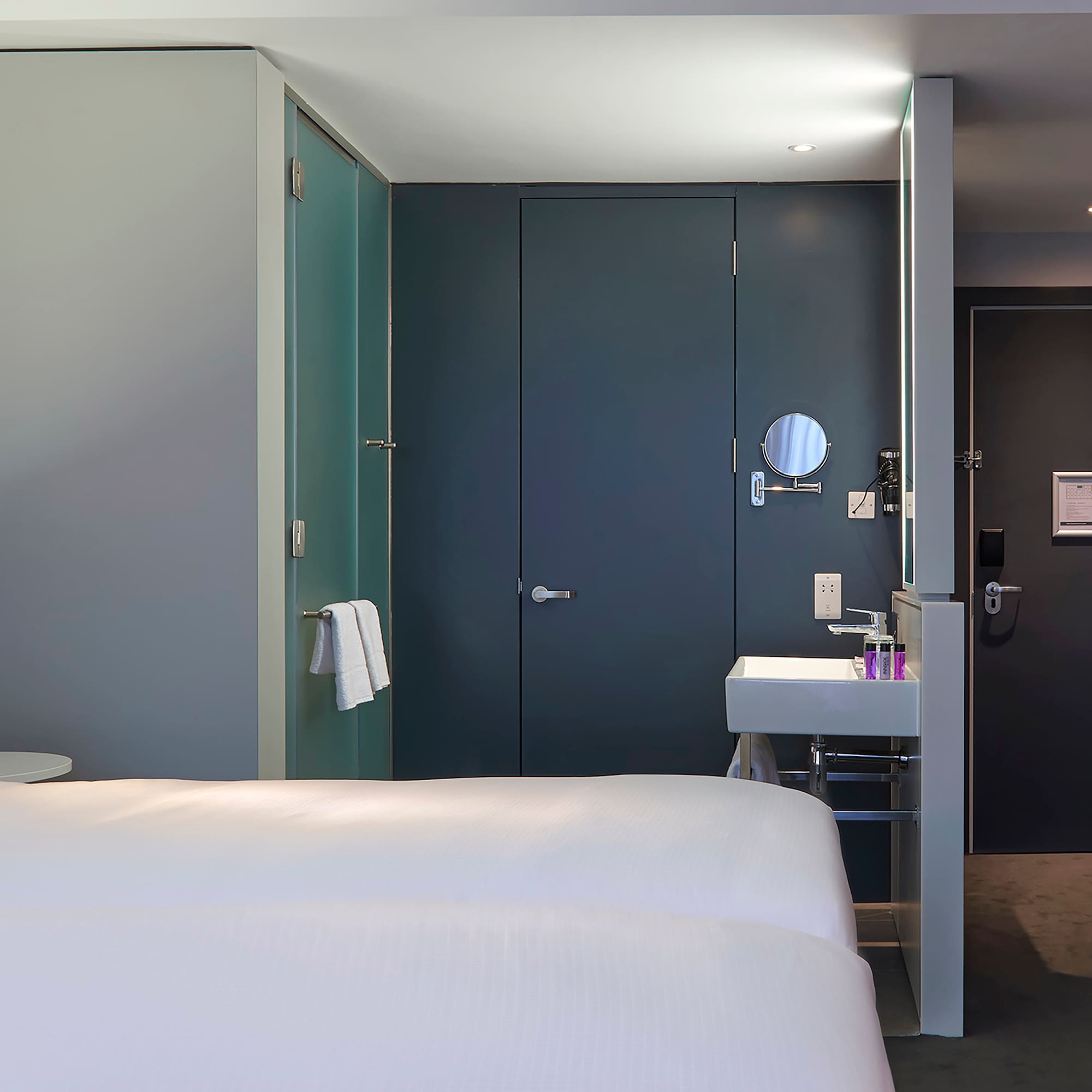 a room with two beds and a sink