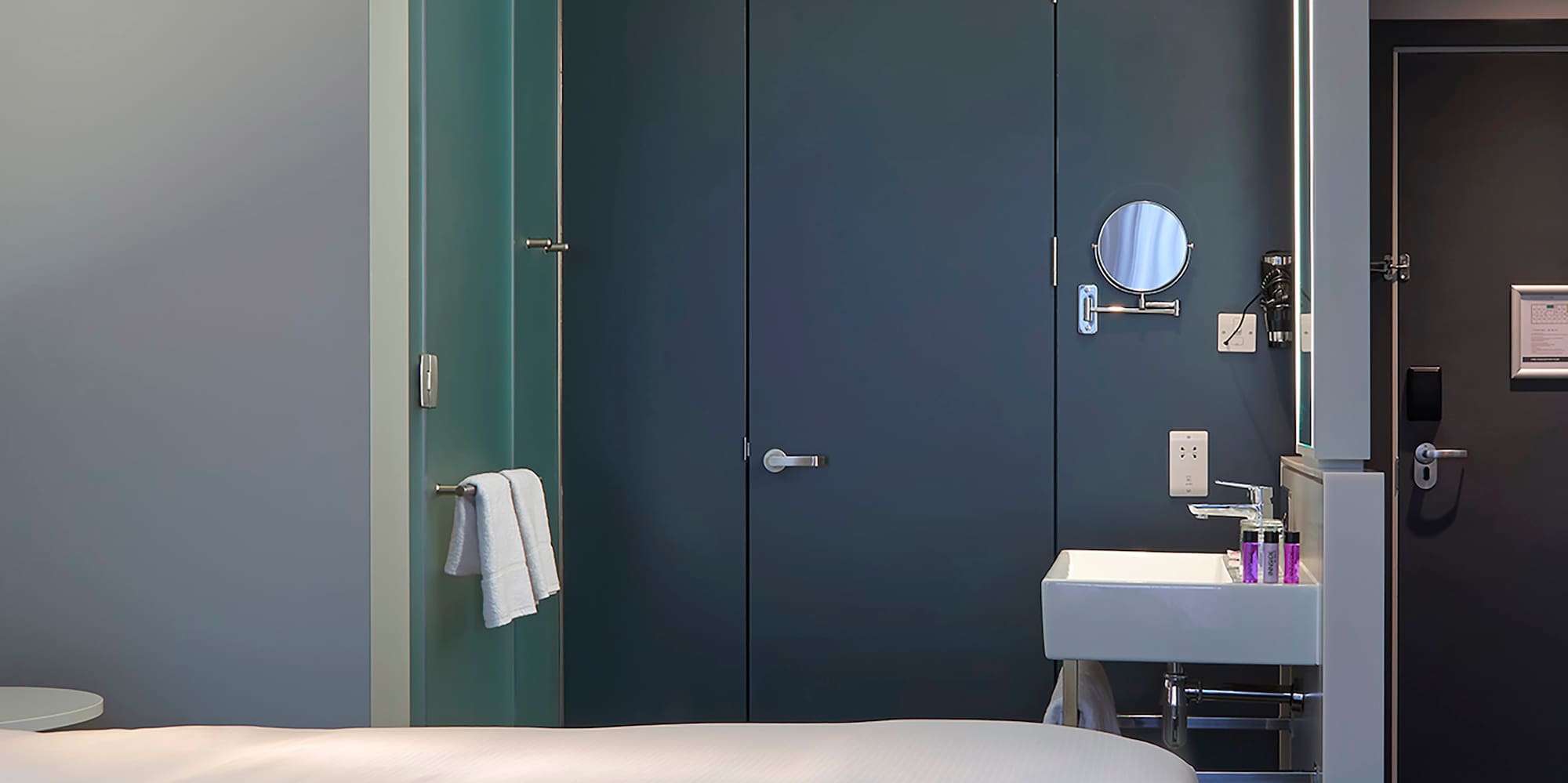 a room with two beds and a sink