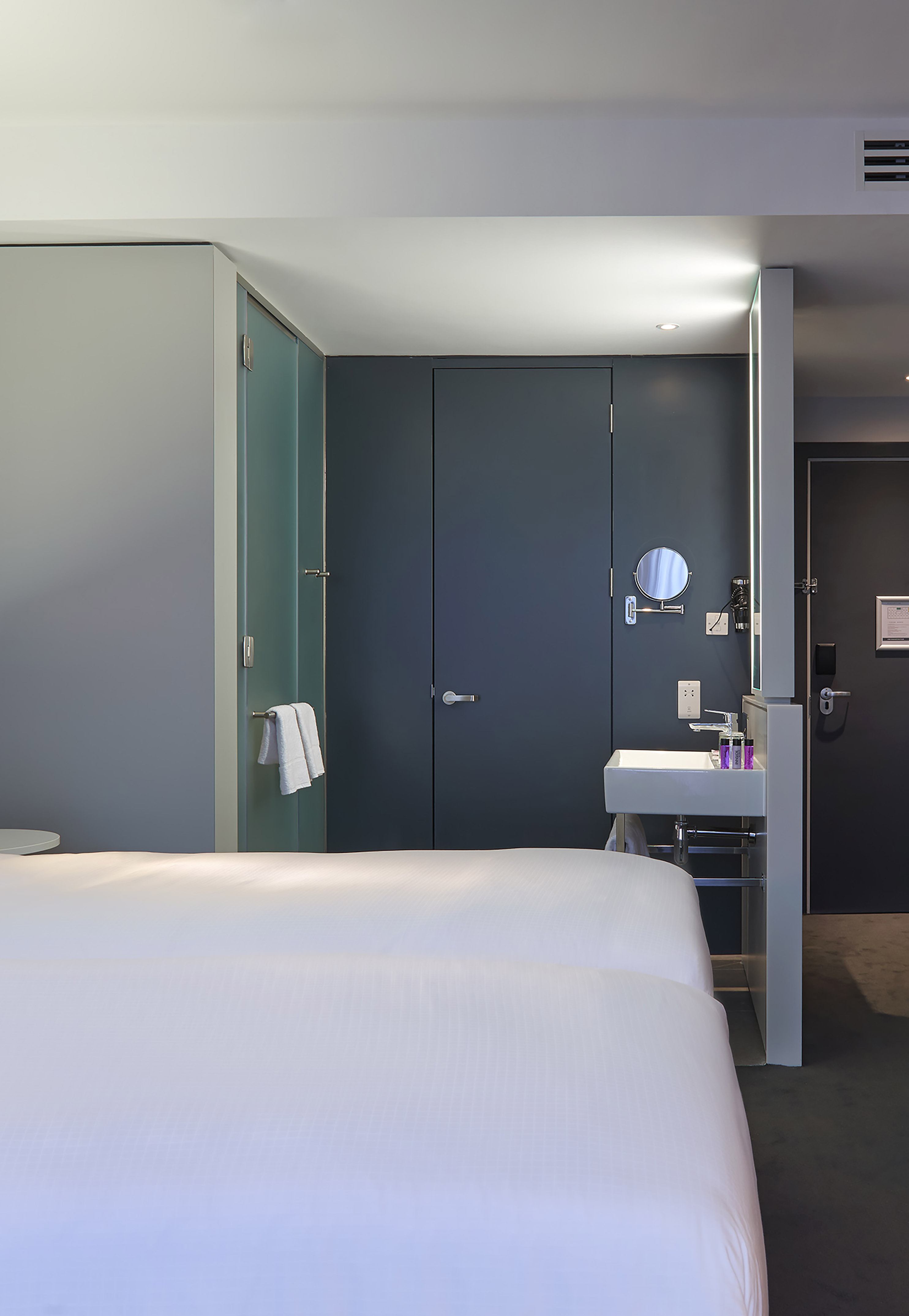 a room with two beds and a sink