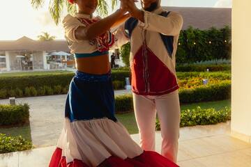 a man and woman dancing in a white and red dress