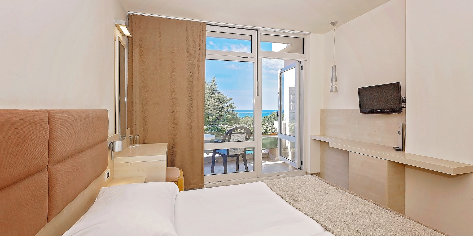 a bedroom with a large bed and a glass door